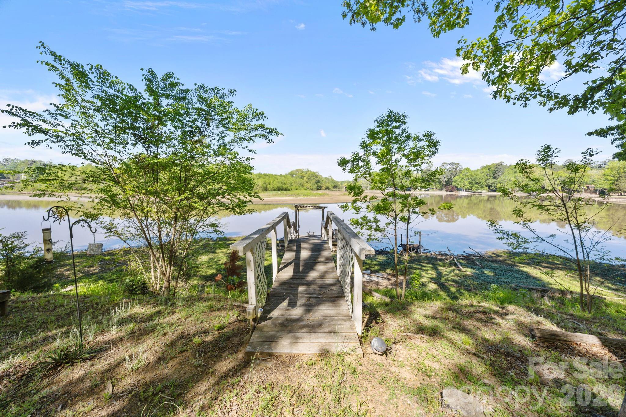 Build your dream WATERFRONT life in this cul de sac lot surrounded by water on two sides. On Crowders Creek that feeds into Lake Wylie. Currently accommodates shallow water activities with future plans to dredge for deeper water, making this a great time to invest. Super convenient location - less than 5 minutes to shopping, restaurants and highways but surrounded by nature at it's best. Enjoy the tranquility of waterfront living, the scenic views of Lake Wylie along with all the Lake Wylie community offers. While the original structure has been lost to a fire, the land remains, with the original foundation still in place, providing a head start for potential buyers.  There is already a dock in place that will need some upfitting.  Community well and septic service this lot. Top Rated schools.