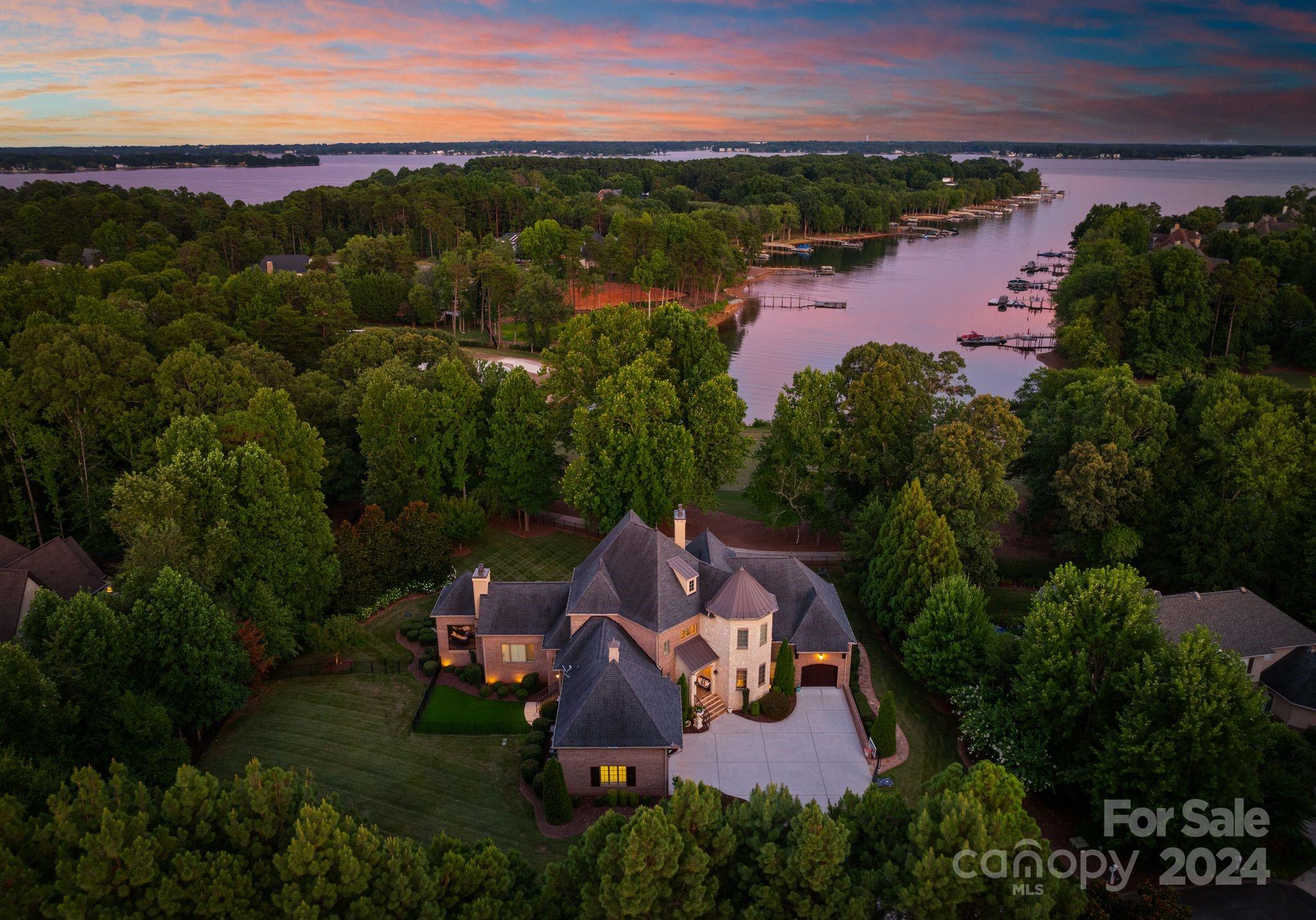 Experience elevated luxury and long-range lake views from this exquisite opportunity in The Point! Beautifully set over the signature 16th hole of Trump National Golf Club Charlotte, this home offers an unparalleled combination of stunning golf course and picturesque Lake Norman views. Refined elegance and detailed architecture is found throughout the home’s expansive three levels which feature a stunning two-story foyer with grand chandelier, gourmet kitchen with Wolf/Sub Zero appliances, and primary suite with cast stone fireplace. The basement level offers a true second living quarters with full kitchen, billiards, media room, guest suite and exercise room. Soak in lake views from the pebble tech saltwater pool and spa or any of the multitude of outdoor living areas. Laundry on all three levels, Control 4 A/V system, 5 BR's plus bonus, and fenced in dog run with astro turf. Club amenities and deeded boat slip nearby allow you to enjoy the very best of resort living at Lake Norman!