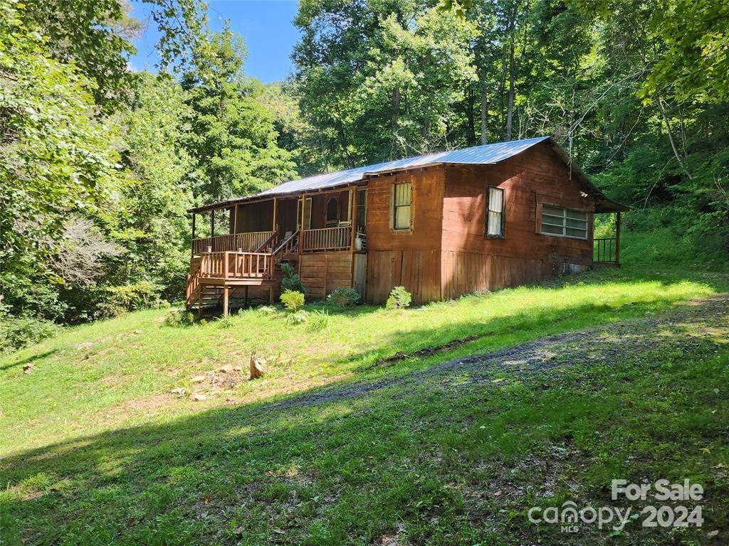 Step back in time in this rustic cabin nestled on 1.4 acre lot. If you love rustic and do not mind character slopping floors, this home is perfect for you. Home is perfect for a mountain getaway or year round living, with plenty of heat sources to tackle the cold winters and a wonderful porch to enjoy those summer evenings. This home has potential for off grid living with spring fed water and wood stoves. Home has a new tin roof, new mini-split system. Come check it out today and make it your mountain getaway home tomorrow.
