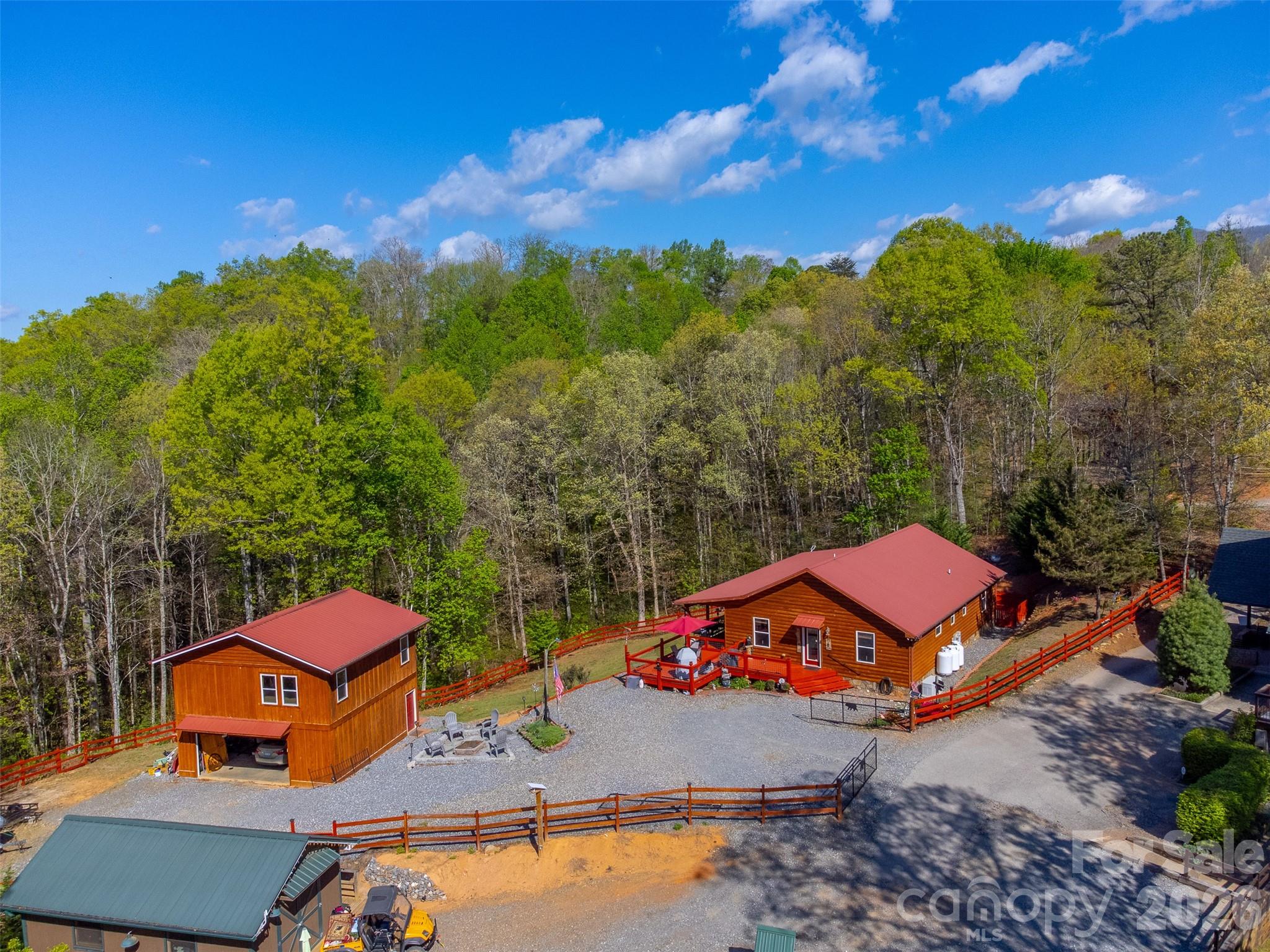 Perfectly positioned between Bryson City and Cherokee, this 1.5-acre property offers the ideal blend of mountain living and income potential within a community allowing short-term rentals. The fully fenced yard provides a safe, usable space for kids and pets. The main 3BR/2BA cabin features a full-length covered porch with hot tub and a sunny open deck. Inside, vaulted tongue-and-groove ceilings and a stone gas fireplace anchor the open living area, flowing into a spacious kitchen with granite countertops, stainless appliances, ample cabinetry, and dining area. The oversized primary suite includes a walk-in closet and ensuite bath with tiled shower, while two guest bedrooms share a full hall bath and large laundry. A heated 2-car garage offers a finished apartment above with living room, bedroom, full bath, kitchenette with bar, and pool table—ideal for guests or rental use. Includes 22KW Generac generator, Balsam West high-speed internet and is being sold mostly furnished. New HVAC in 2025, metal roof's, firepit, automatic gate opener, recently stained cabin and decks....the seller has meticulously maintained this property and it shows!