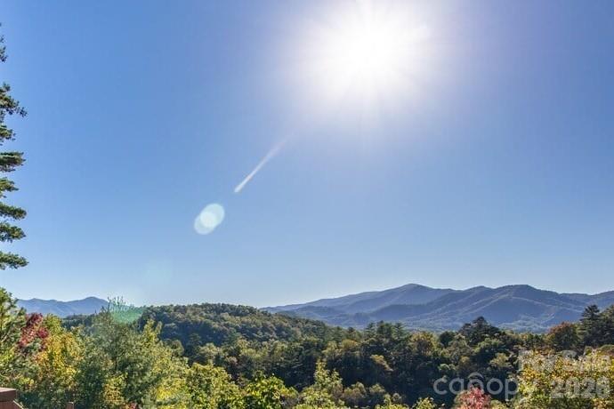 You’ve been waiting for the right property in the right community. This is it. Lookout Lodge sits on 4.32 private acres within Fontana Lake Estates — one of Western North Carolina's most exclusive gated communities, where properties regularly trade between $1M and $3M. At $950,000, this custom Yankee Barn Home represents a rare opportunity to enter this enclave at the lower end of the market, without compromising on the views, craftsmanship, or privacy that define it. Perched atop Nantahala Ridge, the home delivers west-facing, long-range views of the Great Smoky Mountains that are as dramatic in January as they are in October. Post-and-beam architecture, exposed timber beams, soaring ceilings and a great room fireplace were designed to frame that view from every angle. The property lives large: 3 BRs, 3 baths, a main level primary suite, upper loft bedrooms and an unfinished walkout basement — plus a 3-car garage. Outside, a private spa/hot tub, fire pit and screened deck make this a four-season retreat in the truest sense. No neighbors in sight. Currently operating as a successful STR, Lookout Lodge is a turnkey income producer — or the personal mountain legacy home you've been waiting for. Community amenities include gated access, Fontana Lake access, walking trails and picnic areas. Charlotte: 2.5 hrs. Asheville: 1 hrs. Atlanta: 2.5 hrs. Downtown Bryson City, the Nantahala River and Great Smoky Mountains National Park are minutes away.