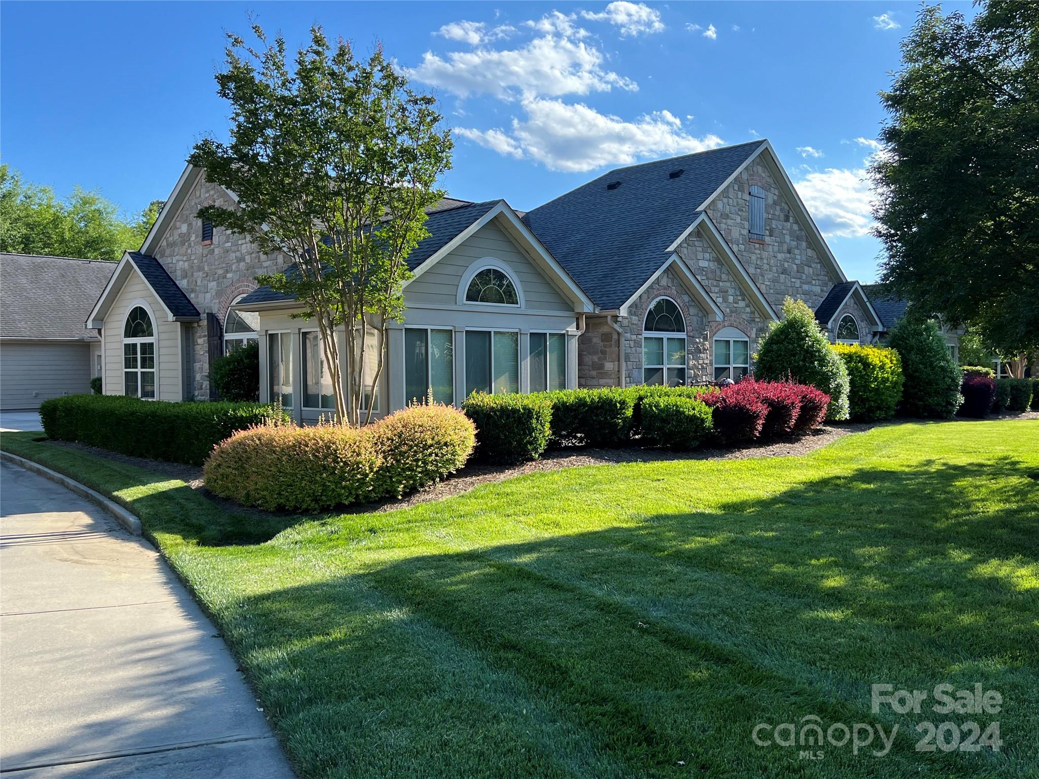 Prepare to fall in love with the highly desirable Canterbury in Stonecrest Villas of Tega Cay. This sprawling, ranch-style, end-unit condo is perfectly nestled by the clubhouse, set back from the road & overlooks lush landscaping/green space. The open floorplan has vaulted ceilings throughout, an abundance of natural light & features a sunroom with french doors, living room with gas fireplace, dining area & large flex room perfect for an office, den or 3rd sleeping area. Kitchen has an envious amount of cabinetry & prep space, a breakfast bar & Corian counters. Spacious Master Suite has dual sinks, walk-in closet & tile shower. A sizeable guest bedroom & bathroom, laundry & storage rooms complete this perfect floorplan. Walk to restaurants, shopping & the proposed Main Street District. COA/HOA includes water, sewer, landscaping, garbage collection, exterior/roof maintenance & resort like amenities (outdoor pool, library, workout facility, clubhouse, parks, pergolas & sidewalks).