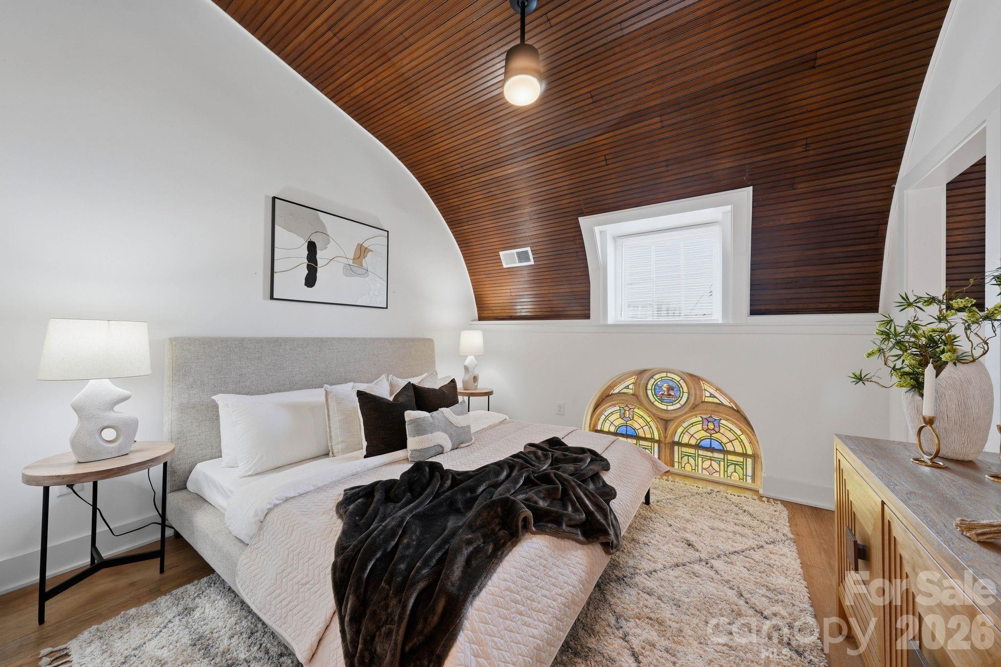 A truly rare opportunity to own one of the most architecturally distinctive residences within The Arches—a boutique collection set inside a meticulously restored 1927 church in the heart of Wesley Heights. Unit 13 showcases some of the most coveted original elements of the building, including stained-glass windows and a dramatic wood vaulted ceiling, seamlessly blending historic character with refined, modern living. Originally constructed as a place of gathering and community, the building has been thoughtfully transformed while preserving its historic integrity and timeless presence. This residence offers a private entrance, creating a sense of individuality and privacy that is rarely found in condominium living. Inside, the main living space is both striking and inviting, defined by soaring ceilings, architectural detail, and abundant natural light filtering through the original stained glass. The open-concept layout flows effortlessly into a beautifully designed kitchen featuring quartz countertops, stainless steel appliances, subway tile backsplash, pendant lighting, and modern cabinetry, offering both functionality and elevated design. Spa-inspired bathrooms include porcelain tile shower walls and floors, complemented by clean, contemporary finishes throughout. The thoughtful layout balances historic charm with modern convenience, creating a unique and highly livable space. Designed for a low-maintenance, lock-and-leave lifestyle, this residence is ideally positioned just minutes from Uptown Charlotte, with easy access to South End, I-77, greenways, and some of the city’s best restaurants, breweries, coffee shops, and entertainment. Walk, bike, or take advantage of nearby transit options to fully experience the vibrancy of Wesley Heights and the surrounding areas. This is more than a home—it’s a one-of-a-kind living experience that captures the essence of Charlotte’s history while delivering the style, comfort, and convenience of modern urban living.