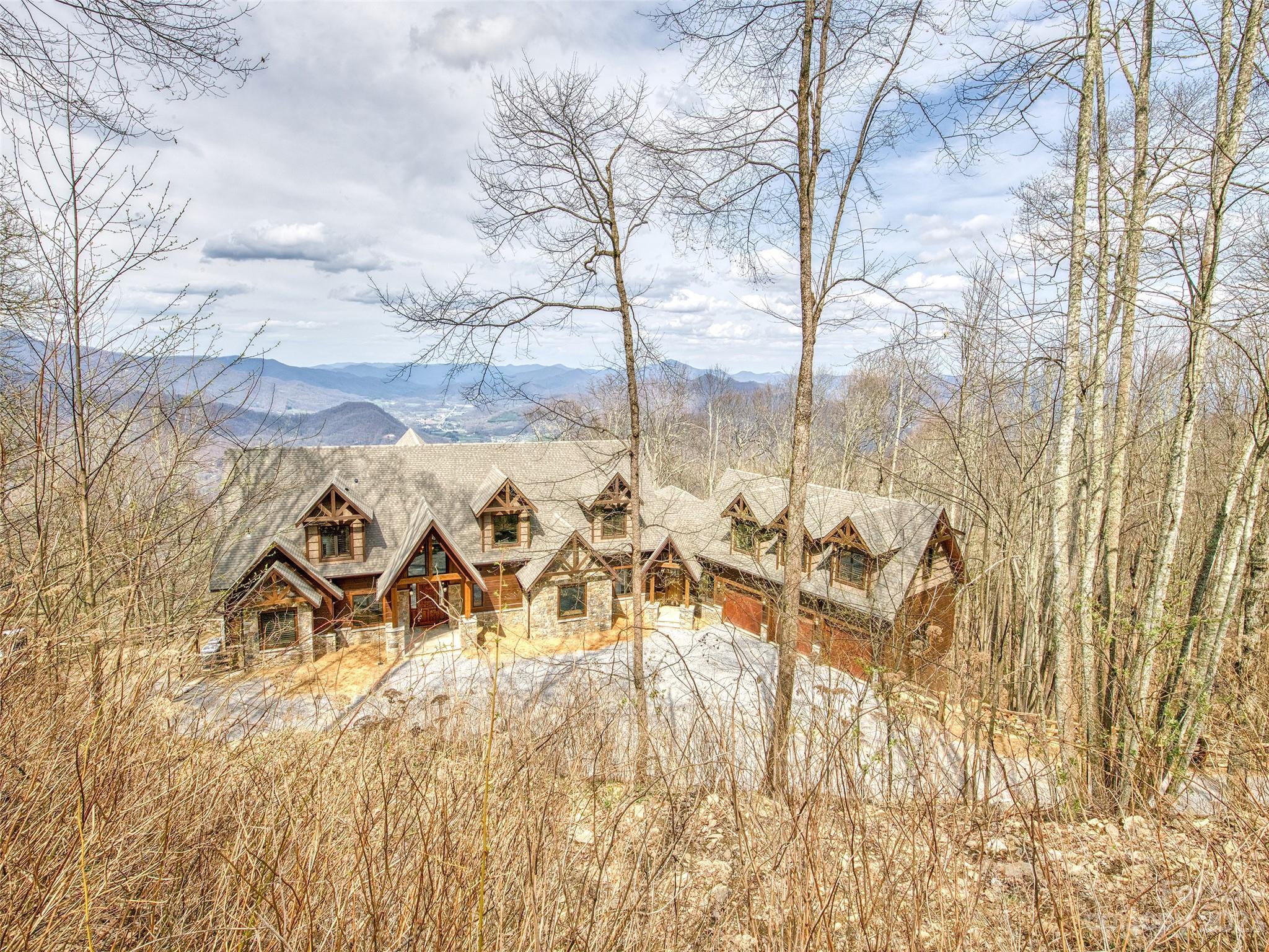Rustic Elegance is the style of this beautiful log home in the Smoky Mountain Retreat at Eagle's Nest. It has an excellent view of Jonathan Valley and the surrounding mountains. It also has a view of the Maggie Valley Country Club. It is a newly built home with an excellent design. Beautifully furnished. The furniture and accessories are included except for some personal items. Great room has 34-foot cathedral ceiling with a tall wall of large windows to enjoy the view. Floor to ceiling stone fireplace with gas logs. The home includes Custom large antler and iron chandelier on a motorized winch. Oak engineered hardwood floors and Old Havana porcelain tile in the guest suite bathrooms. Interior doors are 8' knotty alder. Custom hand-crafted large front entry door featuring the Hawk's Nest. Kitchen opens to the Breakfast Room with outdoor access to decks and screened Pavilion. High end granite countertops with Walnut butcher block at each end of the center island. Viking Appliances.