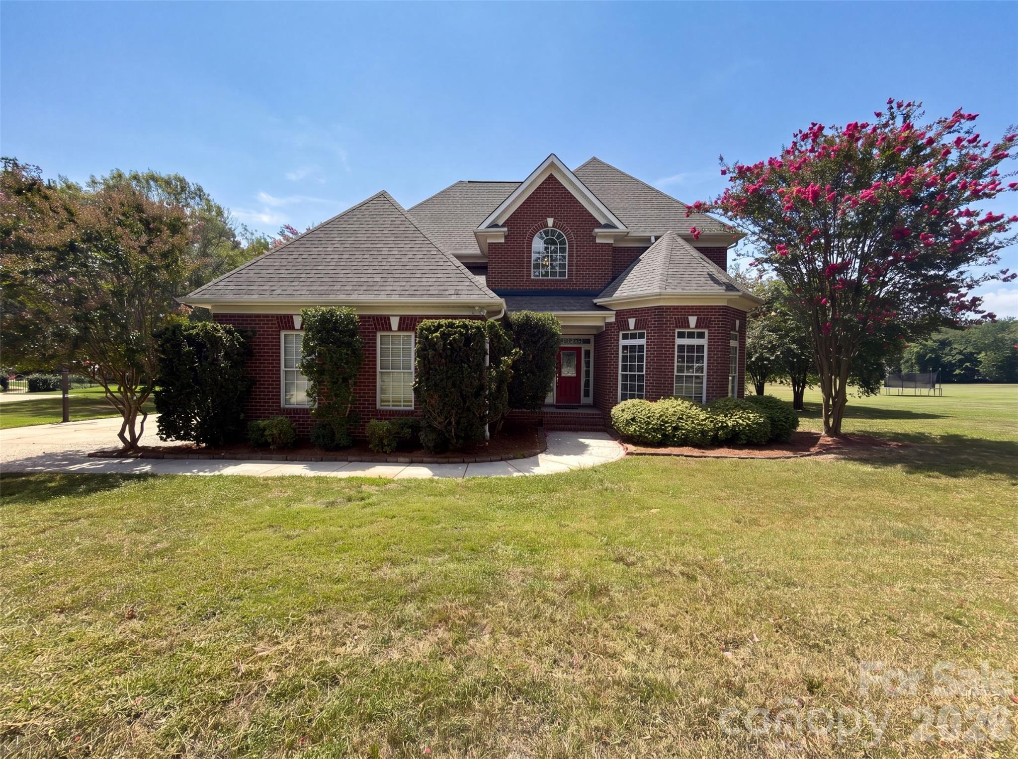 9721 Arlington Oaks Dr is a two-story Charlotte brick home on a cul-de-sac lot. The kitchen features granite countertops, stainless steel appliances, and a center island that provides added prep space and casual seating. The main living area centers on a fireplace that adds warmth, with a separate dining room for larger meals. Upstairs bedrooms include a primary suite with a bathroom offering a soaking tub, a separate glass shower, and a dual-sink vanity for shared morning routines. A rear deck overlooks the spacious backyard for outdoor gatherings. A two-car garage completes this well-maintained residence with practical amenities throughout.. Included 100-Day Home Warranty with buyer activation