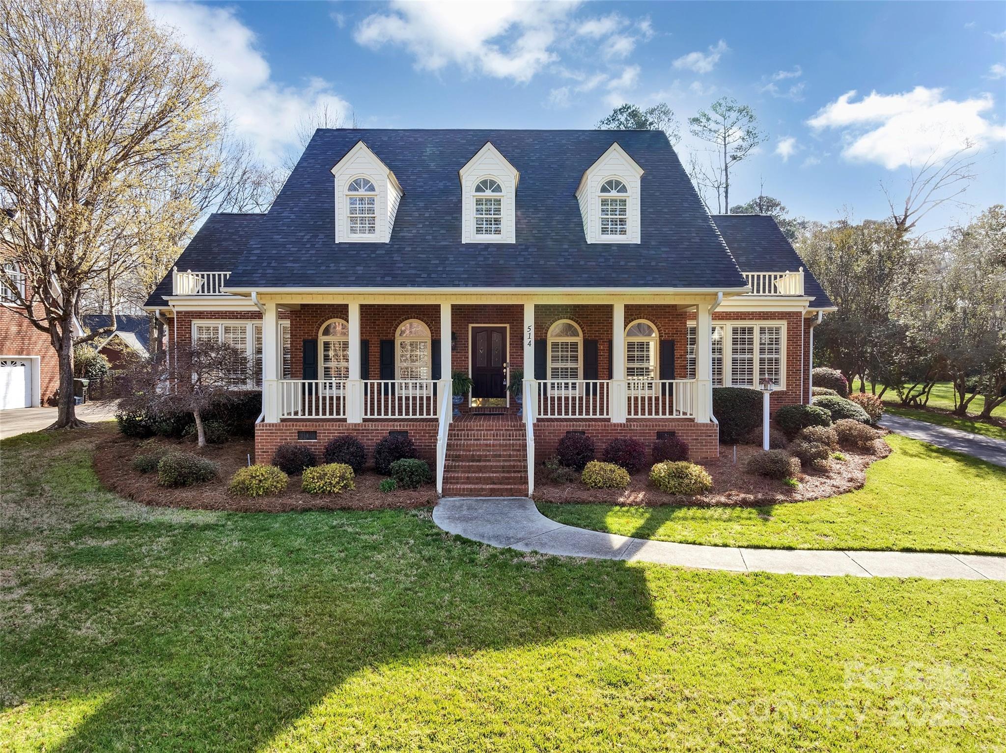 Perched on top a gentle hill, this all-brick classic home offers timeless charm and modern convenience, featuring a large welcoming covered front porch and thoughtful design throughout. With 4 bedrooms and 3.5 bathrooms, including master suites on both the main and upper levels, this home features beautiful hardwood floors, custom plantation shutters throughout, and a spacious laundry room with versatile home office potential. Enjoy seamless indoor-outdoor living with a generous rear deck, covered breezeway, and a blooming backyard garden retreat. Additional highlights include a new roof, tankless water heater, walk-in attic storage, a 2-car garage with separate workshop space, and an extra garage-side concrete parking spot for added convenience.