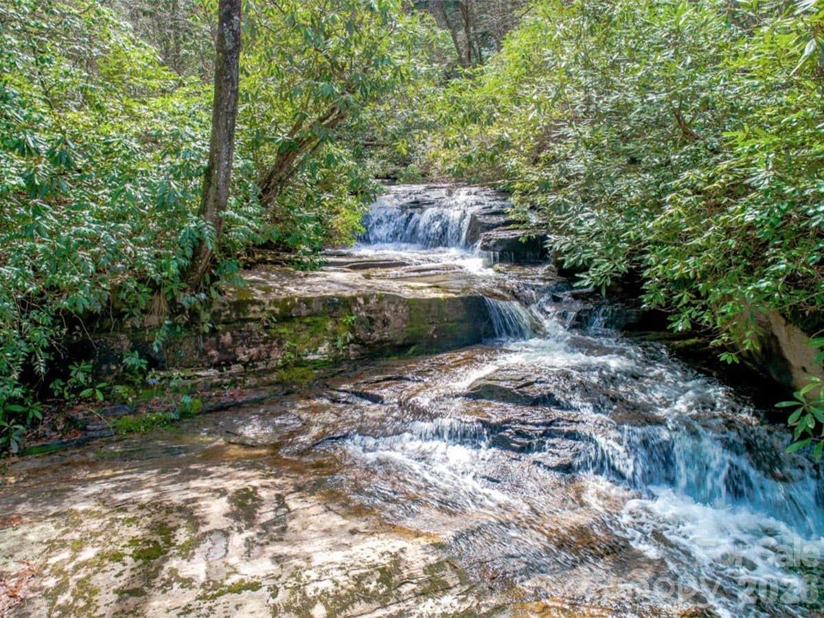 Come experience this beautiful 8.25 acre property in Round Mountain Falls community. Only 25 minutes from downtown Brevard. This unique property has a nice build site for your private mountain getaway or year round residence. This tranquil, low density mountain community is approximately 30’ drive to amazing hiking trails of Gorges State Park and Panthertown Valley backcountry recreation area.Round Mountain Falls has hiking trails to community owned waterfalls, a pond for swimming and fishing and a beautiful pavilion. The Pavilion offers a fantastic venue for entertaining, complete with a massive stone fireplace and an outdoor covered kitchen.If you are looking for land to build your dream home look no further.