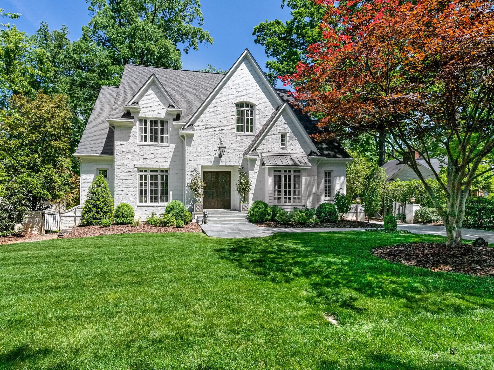 Located on a quiet Myers Park street, this fabulous home first wows you with it's amazing curb
appeal. Double door entry opens to foyer and a private study on one side and a bright
dining room on the other. 10' ceilings on the main with 8' doors. Wet bar connects to the
kitchen which offers large pantry, bar seating and breakfast area overlooking the private, wooded
back yard. Generous family room with fireplace and access to the upper deck perfect for
outdoor dining. Primary on main with 14’ vaulted ceiling. Drop zone and laundry
area at side entrance. 2nd level bonus room and 3 additional ensuite bedrooms. 
Expansive walk-up attic storage. Walk-out basement has 9' ceilings, great natural light and
includes an exercise room, a guest suite with bath, another family room with fireplace, game
room, prep kitchen and storage. Covered patio with wood burning fireplace.Beautiful landscaped backyard designed by Carole Joyner. Gated driveway. This is the one you have been waiting for!