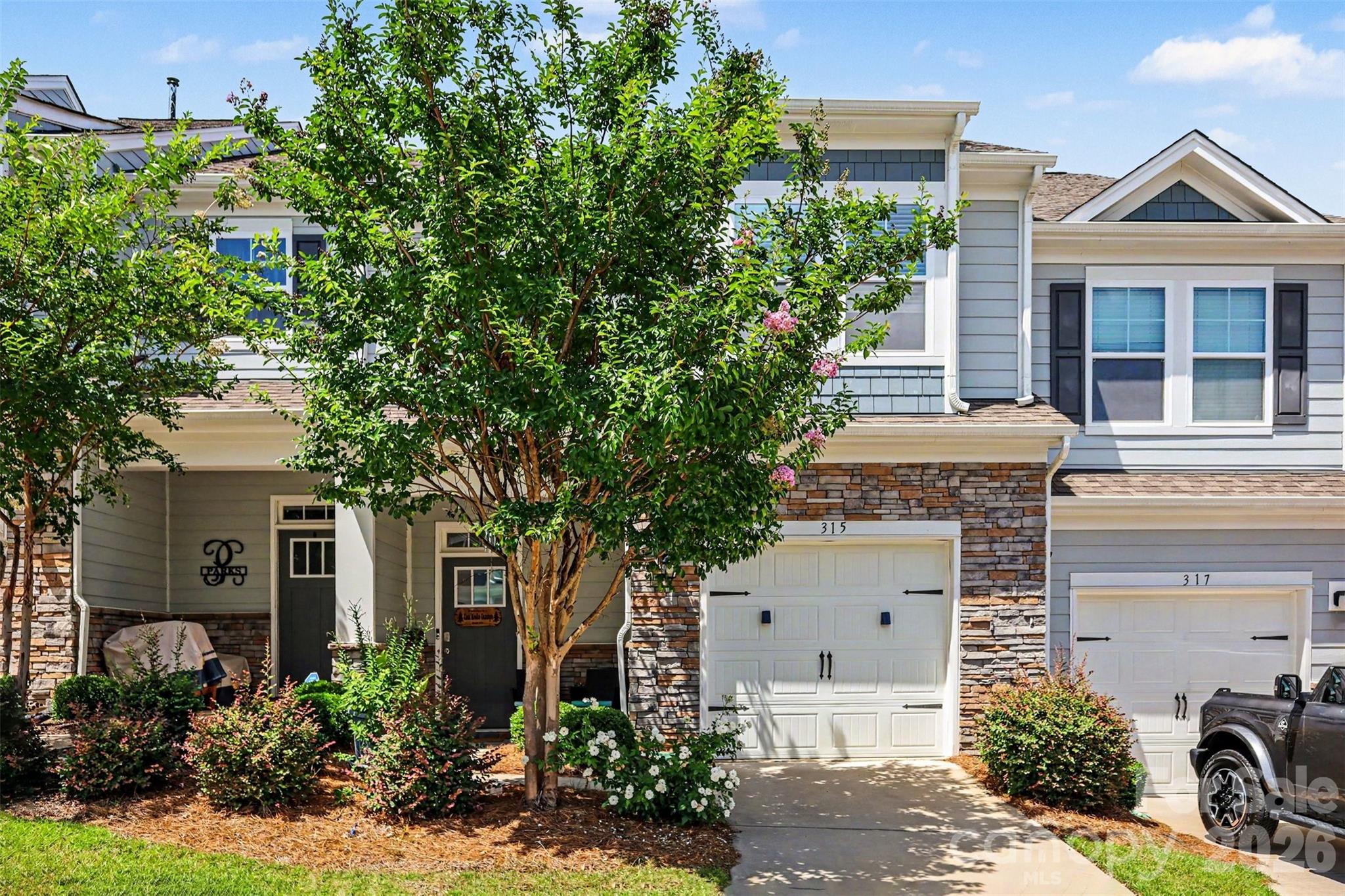 Welcome to 315 Bulrush Road, a beautifully maintained townhome in the highly desirable Village at Ivy Ridge community. Built in 2021, this move-in ready residence offers a bright, open-concept design with stylish finishes and comfortable living spaces throughout. The main level is filled with natural light and features a spacious living area that flows seamlessly into the dining space and kitchen, creating the perfect setting for everyday living and entertaining. The large center island, modern finishes, and generous storage make the heart of the home both functional and inviting.
Upstairs, the spacious primary suite provides a relaxing retreat with ample room to unwind, while two additional bedrooms offer flexibility for guests, a home office, or growing households. Thoughtful details throughout the home, including neutral finishes and well-designed living spaces, create a welcoming atmosphere from the moment you enter.
Step outside to a beautifully landscaped rear patio and outdoor living space—perfect for enjoying your morning coffee or unwinding after a long day. The yard features three pawpaw fruit trees and one uzu fruit tree, along with a thoughtfully maintained herb garden of oregano and rosemary, adding both charm and tranquility to the setting. The attractive exterior with stone accents and manicured landscaping adds to the home's curb appeal, while the attached garage provides convenience and additional storage.
Residents enjoy access to outstanding neighborhood amenities, including a resort-style pool, fitness center, playground, picnic areas, and beautifully maintained common spaces. Located in the thriving Lake Wylie area, this home offers easy access to shopping, dining, parks, golf courses, and recreational opportunities along Lake Wylie. Enjoy the charm of nearby downtown Clover while remaining just a short drive from Charlotte, providing the perfect balance of small-town living and metropolitan convenience.
This exceptional home combines low-maintenance living, modern style, and an unbeatable location in one of the area's most sought-after communities.