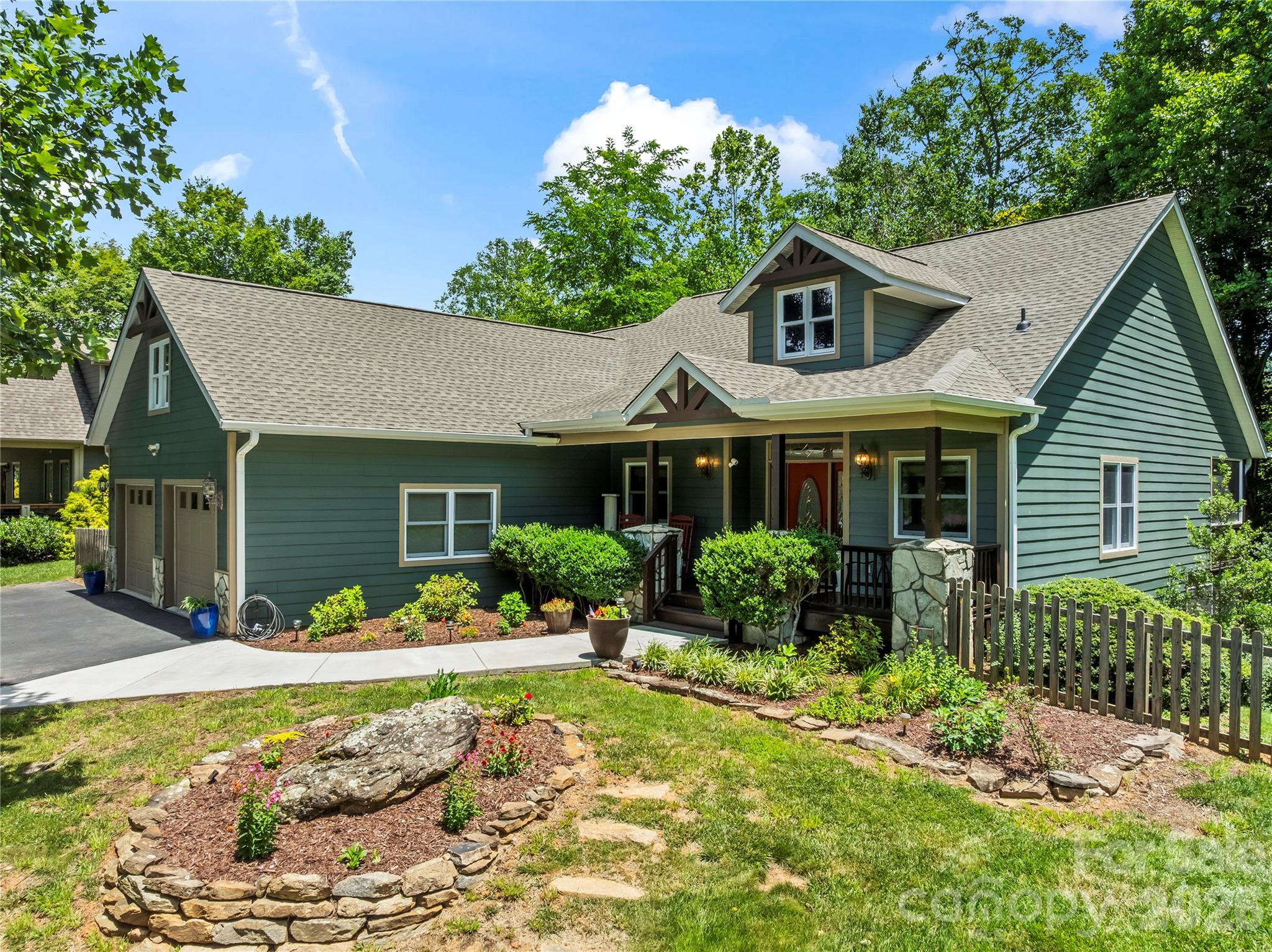 A rare opportunity into this well loved home in one of the most treasured neighborhoods in Waynesville.  Mountain Creek Estates is located 2.5 miles via Pigeon St/276S. New roof, new heat and cool, 2025,  fresher paint on the sparkling cement siding exterior. Proper covered front entrance faces the year round breath taking views. Weatherproof with entrance into oversized 2 car garage and into laundry/mudroom with pantry and ample storage.  Catheral and tray, and 10 ft ceilings bring natural light into this comfortable 3 bedroom, 3 full, 1 half bath home. 2 primary suites one main and the other below. Greatrooms on both levels open to screened and open decks. Lower level office space off greatroom, split plan offers company privacy and private exits to decks, screened deck which opens to side fenced yard for pets.  Continue through yard, short distance from house is new 2025, insulated, with seperate electric service, studio/office/shop. Rolling lot with mature shady landscape and numerous blooming perennials in well layed flower beds.