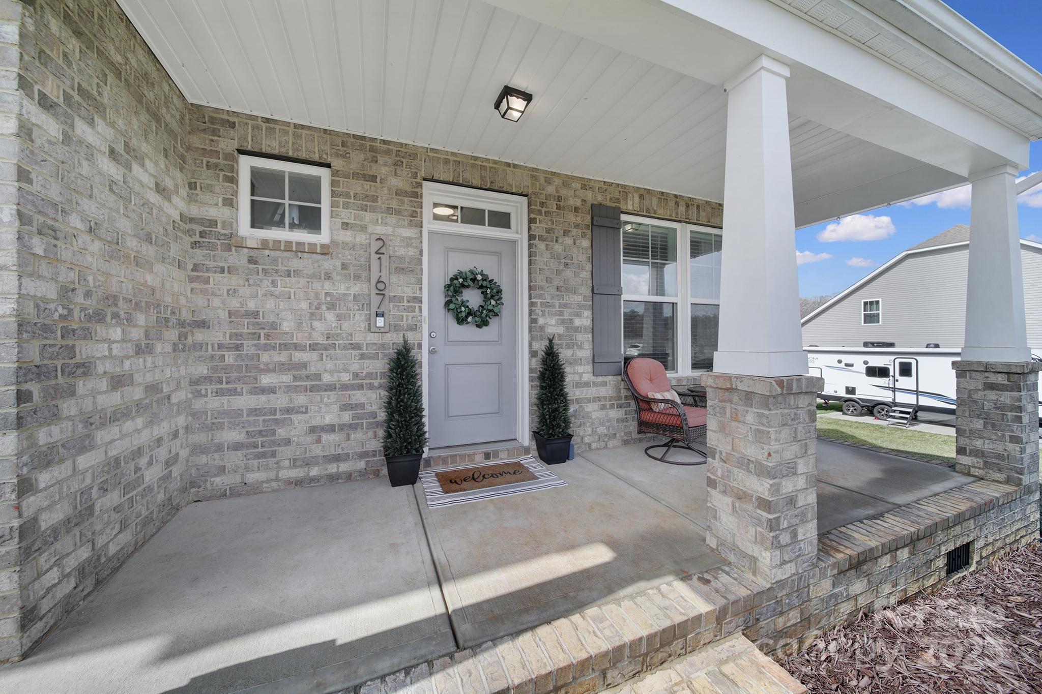Don't miss your opportunity to own this stunning home set on over an acre, backing to a lush wooded backdrop for ultimate privacy. A charming front porch and impeccable architectural details create a warm welcome. Inside, the main level boasts durable LVP flooring and an open, light-filled floor plan. Arched doorways from the foyer lead to a dining room with coffered ceilings and flow seamlessly into the stylish kitchen—featuring quartz countertops, a large prep island, stainless steel appliances, and a herringbone-patterned subway tile backsplash. The spacious living room is anchored by a cozy gas fireplace.  Upstairs, a versatile loft—currently used as an office—complements generously sized bedrooms, all with LVP flooring. The primary suite is a true retreat, showcasing a vaulted ceiling with a fan, a spa-like en-suite bath with large walk-in shower/separate tub, a private water closet, and a large walk-in closet. The garage offers additional storage. All this and more. Don't wait!