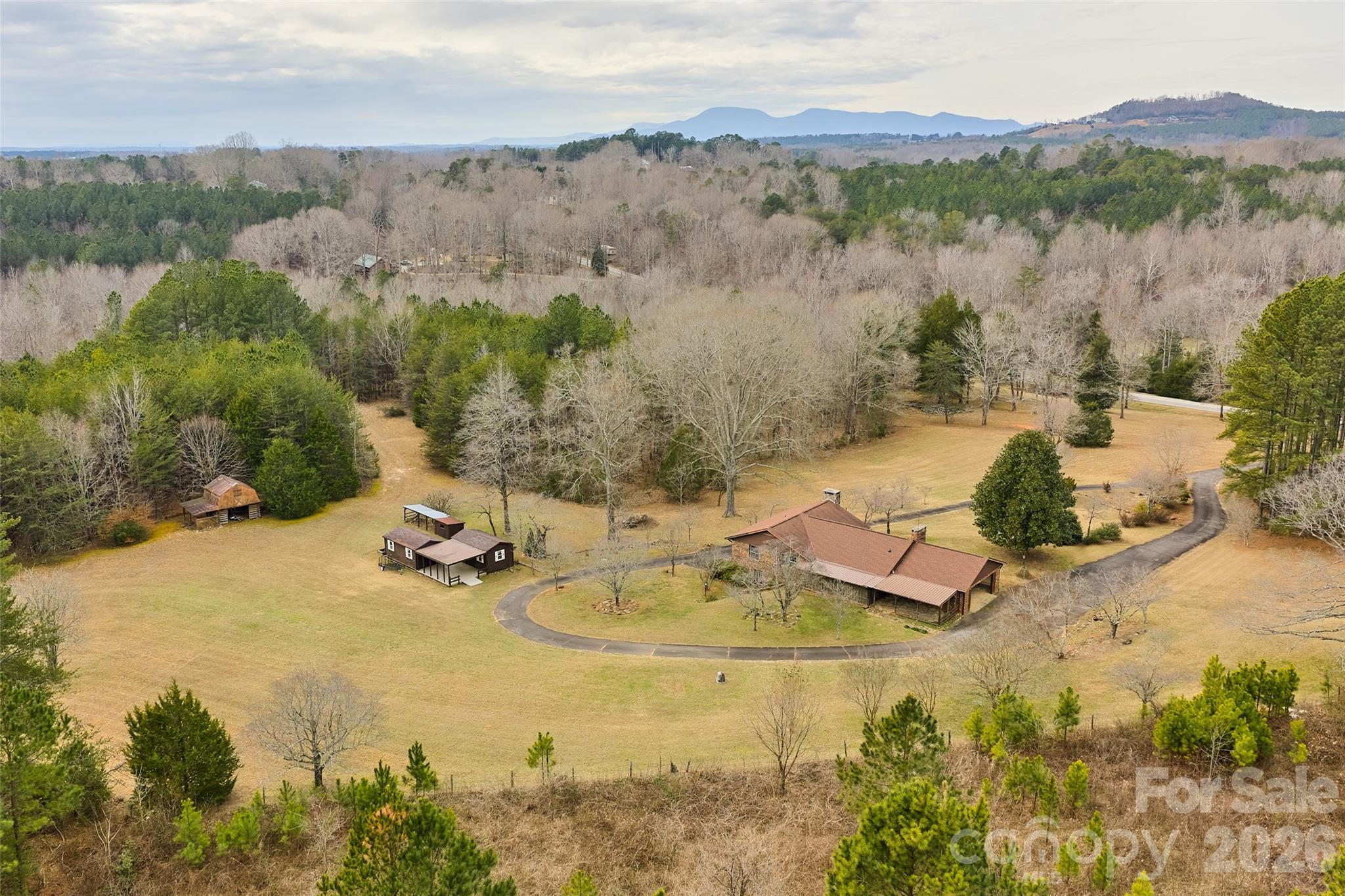 First time on the market! Properties offering this much usable land are increasingly rare. Welcome to this solid brick 5-bedroom, 3.5-bath home with a basement apartment, ready for your personal updates.  With approved connection to the highly sought-after CETA horse trail system, this property offers an exceptional opportunity for an equestrian farm. The property spans 20.22 acres of mostly usable land, including approximately one acre along the creek line within the floodplain.   Only 5 miles to TIEC!!!  3 miles to Tryon Equine surgical hospital!!  Additional features include a log barn with loft, a shed with overhangs currently used as a chicken coop, and two attached outbuildings with covered concrete patio. There are no restrictions other than zoning, allowing for a wide range of potential uses. The possibilities are truly endless.  Inside, the home features solid oak hardwood floors in the living room and all main-level bedrooms. The well is equipped with a water filtration system, and the roof was replaced in 2017. Outdoor living spaces include a large screened porch and a covered rear patio, ideal for enjoying the surrounding landscape.  Conveniently located across from the desirable Derbyshire community, the property also includes Collinsville Creek along the southern boundary. 5.4 miles to I-26 and 5.8 to Ingles  Short drive to quaint Landrum, SC with historic buildings and it's own horse trailer parking!!!  Additionally, 663 Landrum Road (5 acres) is available for purchase—see MLS #4315052 for details.
