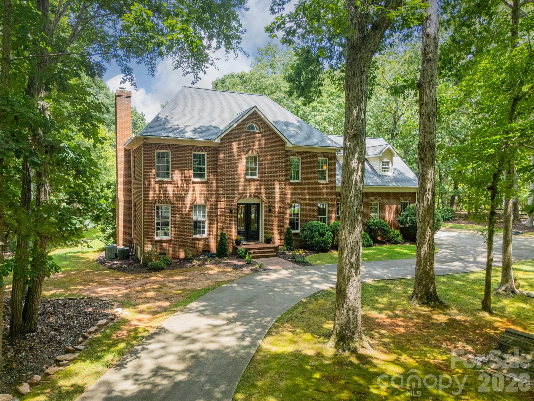 Welcome to this elegant all-brick estate nestled on 5 serene acres in the heart of Marvin. Designed with timeless appeal and built for both comfort and entertaining, this stately 4-bedroom home offers privacy, space, and flexibility, complete with a sparkling in-ground pool and spa.
The main level features rich hardwood floors, spacious living areas, and a cozy wood-burning fireplace. A generous kitchen open to the family room plus formal dining room provide the perfect backdrop for family gatherings. The living room/office lends that much loved flex space for office or second seating/entertaining space on the main floor. Upstairs, you'll find the expansive primary suite offering peaceful views and a spa-like bath, along with three additional bedrooms, two full baths and two versatile bonus rooms, ideal for a home office, media room, or guest suite.
Step outside to enjoy the best of Carolina living with screened porch, large deck, private pool area, stone fire pit, and open, flat land perfect for recreation or future equestrian use. Oversized two car garage with workshop with separate entrance. This property offers a rare blend of sophistication and outdoor lifestyle just minutes from top-rated Marvin schools, multiple grocery stores and Lowe's, charming downtown Waxhaw and shopping at nearby Blakeney and Waverly. Homes in Providence Estates do not come on the market often, don't miss this opportunity! Showings begin Saturday April 25.