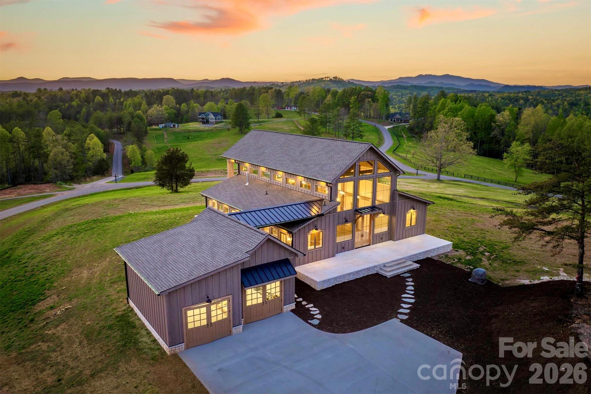 On a knoll with astounding Blue Ridge Mountain views at The Coves Mountain River Club is an architectural marvel, custom built, combining barn inspired exterior charm with a luxury, rustic contemporary interior. Approved as a small farm, the lot is 1.99 acres, Adjacent 1.75 acre lot is also available. The grand front porch is adorned with a striking gable truss supported by timber + stone columns. 2 story windows and 10' French doors flood the open floor plan with natural light, and frame panoramic long range mountain view on the horizon. A warm, stone central fireplace is flanked by built-in cabinets. The kitchen is a place for culinary creativity and social gatherings; an aesthetic wonder with counter-level stone fireplace, professional grade IVLE range, KitchenAid full-size refrigerator+freezer combo, stone farm sink, a massive island, and double stacked cabinetry. Retire to your primary bedroom and luxury spa bathroom with warm gold hardware, step-in shower (builder to install glass doors of your choice), and stone sculptural vessel sinks. Collaborate with the builder to create more space with a loft/2nd floor within the existing home (price to be determined).This magnificent home occupies a premium home site in the South’s premiere Outdoor Lifestyle community, The Coves Mountain River Club.  

The Coves is a 3,200 acre gated community in the Blue Ridge Mountains of North Carolina. There are miles of community exclusive trails to hike, bike, ride horses, or UTVs. There are 5 miles of frontage on the Johns River, with areas to put in and take out your kayak, wade and fish, picnic, or gather round a stone fire pit. The crown jewel of The Coves is the magnificent post and beam constructed clubhouse, Pisgah Lodge, located on one of the highest peaks. There, you'll enjoy a saline pool, fitness center, locker rooms, full kitchen, lending library, pool table, fire pits, wrap around porches, decks, and overlooks to take in 360º views of the Blue Ridge Mountains, South Mountains, and Brushy Mountains. The Coves is a Firewise USA® Community, a program of the National Fire Protection Association, that helps neighbors organize to reduce wildfire risk, harden homes, and create defensible space by managing vegetation and preparing for wildfires. Down by the river you can garden your private plot at the Community Garden or join your neighbors to care for and harvest the community cooperative vineyard. Pickle-ball and shuffleboard courts, putting green, and a picnic pavilion are located at another Coves's park, Wyatt's Landing. Additional amenities include 2 Equestrian Centers and a Dog Park. Join your neighbors for social events, excursions, hiking, travel, yoga. *500K acre Pisgah National Forest and the Wilson Creek Wild and Scenic River Area are across the road! 1.25 hour drive to Charlotte or Asheville, minutes to Lenoir, Blowing Rock, Morganton, and the Blue Ridge Parkway.  Contact Arrow Realty & Land Development today!
