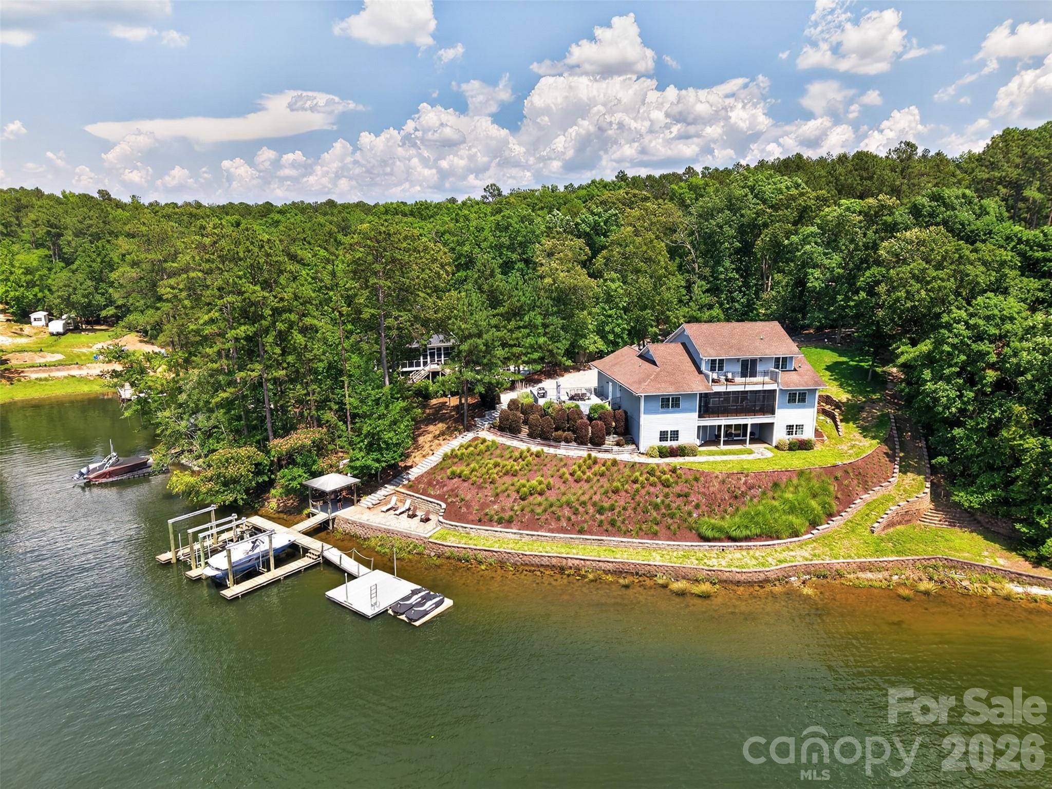Fantastic Lake Wateree home with gorgeous main channel sunset views! This custom build beauty was new in 2006 and has been perfectly maintained. Offering 4 bedrooms and 4 full bathrooms, plus 5th and 6th rooms used as bedrooms and enough heated/cooled storage space for more. The kitchen is a chef's dream with ample granite counter space, custom maple cabinetry with double-deep cabinets fitted with pull-out roller shelves for easy access, built-in gas cook-top, double stainless ovens; the works! You’re greeted by a craftsman style rock entry leading to a majestic foyer with soaring high ceilings, wrap-around staircase to the balcony. The master suite is stunning, complete with a huge dual wet-wall walk-in shower that you'll never want to leave. Hardwood floors on the main, high smooth ceilings, heavy moldings; just gorgeous. One of the 2nd floor rooms is a suite in itself, complete with a den-like seating area and private veranda. Porches on every level to enjoy the lake and your own private outdoor hot tub! Hardscaping, landscaping, shoreline stabilization, and an elaborate dock with 2 boat lifts and 2 jet-ski ports are in-place and ready to enjoy. This home needs nothing but a new owner to make new memories!