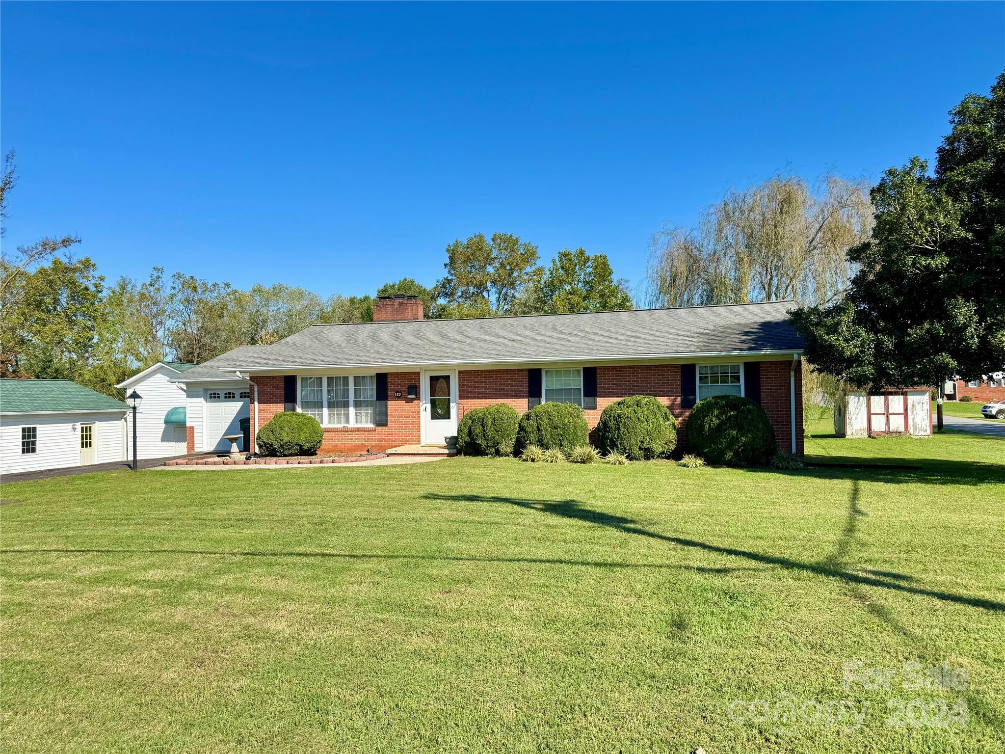 This well-built brick ranch offers a prime location in town, providing convenient access to shopping, schools, and recreational activities.The interior features beautiful hardwood flooring throughout, enhancing the home.The versatile sunroom can serve as a third bedroom, while the kitchen boasts granite countertops and oak hardwood cabinets, creating a warm and inviting atmosphere.Natural light floods the space, complemented by ample storage options, including a walk-in closet.The outdoor area is equally impressive, featuring a gazebo and a level yard, perfect for relaxation or entertaining.Additional amenities include a one-car garage and a full basement, providing extra storage or potential for further development.The primary bedroom features a remodeled tile shower bath.The open-concept kitchen and dining area promote a seamless flow for gatherings.Located near hiking trails, downtown Elkin,and local wineries, this property combines comfort and convenience. No HOA.