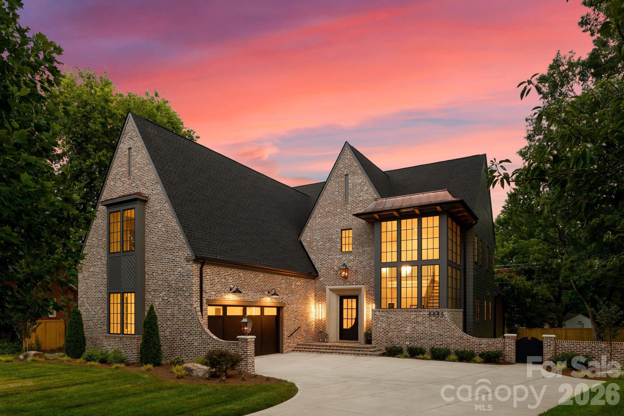 Set in the heart of one of Charlotte's most sought-after and rapidly growing communities, this 5-bedroom, 4-bath luxury model home showcases modern craftsmanship and timeless design. Spanning 5,310 square feet on a rare .56-acre homesite, this courtyard-style residence balances scale, privacy, and architectural presence in a way few homes can. The exterior makes an immediate statement with classic brickwork, steep gables, and refined contemporary accents. Inside, the layout is both intentional and effortless. The primary suite on the main level offers a private retreat, thoughtfully positioned for comfort and convenience. Open-concept living spaces flow naturally toward the courtyard, creating a seamless indoor-outdoor experience ideal for entertaining or relaxed evenings at home. The kitchen is designed for both beauty and performance, featuring premium finishes and a fully equipped scullery kitchen that keeps the main space polished and organized. Upstairs, generously sized secondary bedrooms and an expansive bonus room provide flexible space for media, work, or play. Thoughtful design, abundant natural light, and carefully curated details create a home that feels elevated yet livable, offering luxury, comfort, and exceptional everyday living.