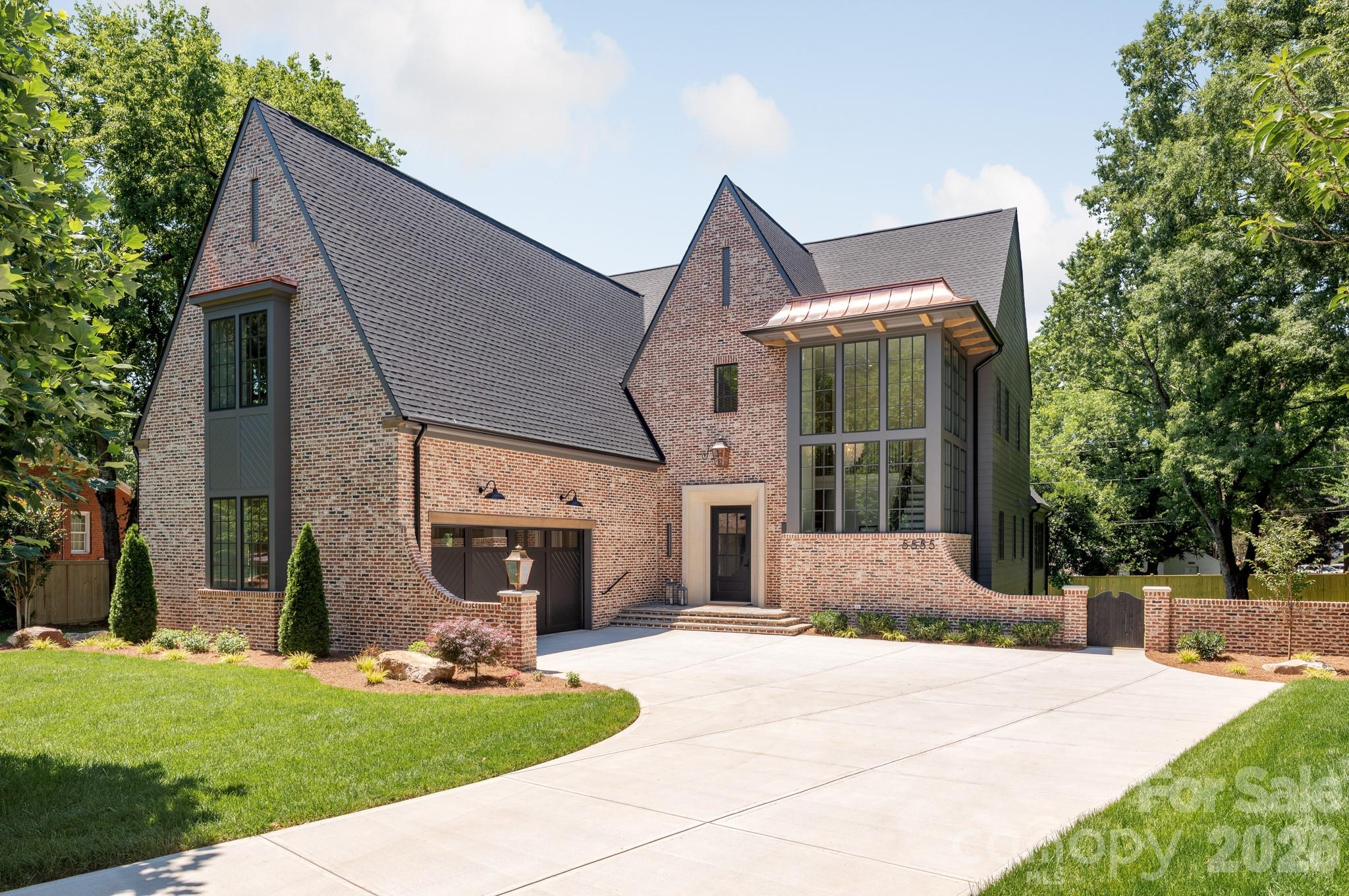 Set in the heart of one of Charlotte's most sought-after and rapidly growing communities, this 5-bedroom, 4-bath luxury model home showcases modern craftsmanship and timeless design. Spanning 5,310 square feet on a rare .56-acre homesite, this courtyard-style residence balances scale, privacy, and architectural presence in a way few homes can. The exterior makes an immediate statement with classic brickwork, steep gables, and refined contemporary accents. Inside, the layout is both intentional and effortless. The primary suite on the main level offers a private retreat, thoughtfully positioned for comfort and convenience. Open-concept living spaces flow naturally toward the courtyard, creating a seamless indoor-outdoor experience ideal for entertaining or relaxed evenings at home. The kitchen is designed for both beauty and performance, featuring premium finishes and a fully equipped scullery kitchen that keeps the main space polished and organized. Upstairs, generously sized secondary bedrooms and an expansive bonus room provide flexible space for media, work, or play. Thoughtful design, abundant natural light, and carefully curated details create a home that feels elevated yet livable, offering luxury, comfort, and exceptional everyday living.