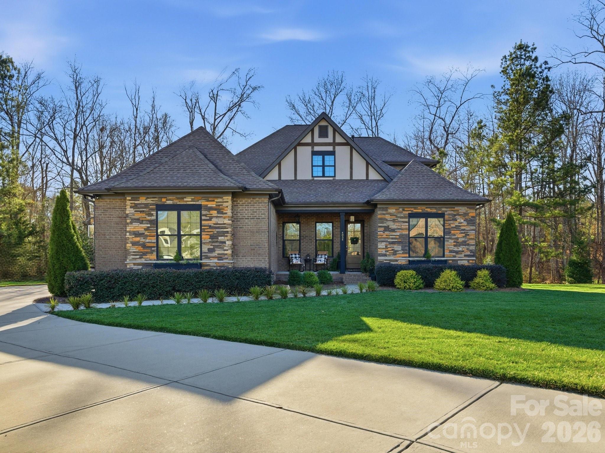 Welcome to 4034 Flagstone Drive, a beautifully crafted custom home in the highly coveted and desirable Millstone Creek community, set on a private 1-acre lot with serene, wooded views.

Offering 3,855+ heated square feet, this exceptional home features 4 bedrooms, 3 full baths, a large loft, two additional flex rooms with closets and a 3-car garage, thoughtfully designed for both everyday living and entertaining. The open-concept layout is anchored by a striking great room with fireplace, coffered ceiling, custom built-ins, and extensive millwork that highlights the home’s superior craftsmanship and attention to detail.

The owner’s suite on the main level provides a peaceful retreat, while generously sized secondary bedrooms and a spacious loft offer flexibility for guests, a home office, or additional living space. The chef-inspired kitchen is complemented by a custom walk-in pantry, and the well-appointed laundry room continues the theme of thoughtful design with built-ins and elevated finishes rarely found at this level.

Outdoor living is equally impressive. A massive rear deck overlooks tranquil wooded scenery, creating a private backdrop for morning coffee or evening gatherings. Below, a stamped concrete patio with an outdoor fireplace offers an inviting space for year-round enjoyment and entertaining. Want a pool?  Check out images for an awesome pool concept idea designed by Edgewater Pools! 

Ideally located in one of the most sought-after large lot custom home communities, this home delivers refined design, custom details, and a serene setting.  Just minutes from everyday conveniences. About 20 minutes to South Charlotte, Ballantyne.  Incredible shopping and dining options - PLUS nearby Harris Teeter, Publix, Lowes, Target and Costco!