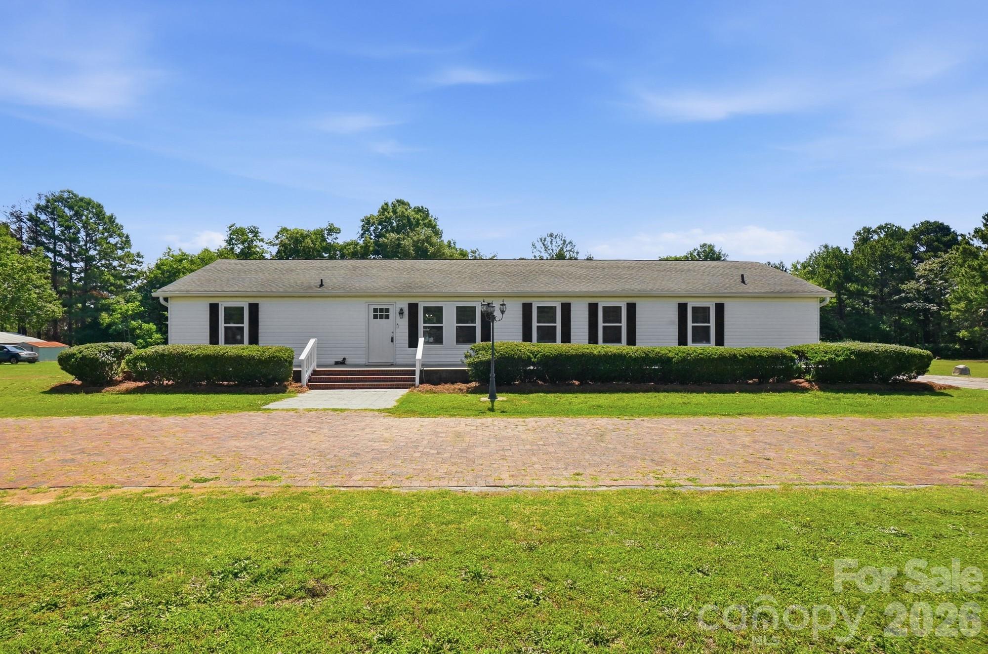 ****100% USDA financing eligible *****
Welcome home to this spacious 4-bedroom, 2-bath modular home nestled on 1.62 acres in desirable Clover, South Carolina. Offering the perfect blend of comfort, functionality, and outdoor enjoyment, this property is conveniently located just minutes from downtown Clover while providing plenty of room to spread out and enjoy country living.

The thoughtfully designed floor plan features a large primary suite complete with a private study—ideal for a home office, nursery, or quiet retreat. The ensuite bathroom offers a luxurious setup with a double vanity, separate soaking tub, and walk-in shower.

Outside, you'll find exceptional amenities for entertaining and recreation. Relax by the above-ground pool surrounded by a spacious patio area, perfect for gatherings with family and friends. The fenced backyard provides privacy and plenty of space for pets, play, and outdoor activities.

Additional highlights include a detached wired building, with a kitchen that offers endless possibilities for a workshop, storage, hobby space, or home business. There is also an outdoor shower behind the building. The attractive brick and concrete circular driveway enhances curb appeal and provides ample parking for guests.

Don't miss this opportunity to own a beautiful property with acreage, modern conveniences, and a prime location near all that Clover has to offer, including the sought-after Clover schools.