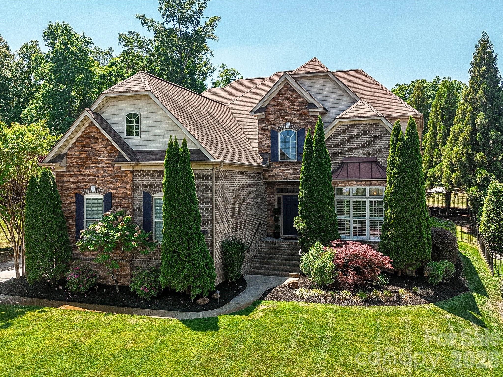 NEW PRICE!! Step into elegance and comfort in this beautifully appointed home where thoughtful design meets timeless finishes. Full Brick/Stone exterior, Primary suite is on the main floor, 3 Additional bedrooms upstairs, a huge Bonus room and 3.5 baths in the home.
A welcoming foyer opens to a formal sitting and dining room, highlighted by vaulted ceilings and detailed millwork—perfect for hosting gatherings or enjoying quiet moments in style. Rich oak hardwood floors flow throughout the main level, complemented by plantation shutters on the main level that add charm and privacy across the entire home.
The heart of the home is a stunning two-story great room featuring a dramatic floor-to-ceiling stone gas fireplace, creating a warm and inviting focal point. The adjoining kitchen is a chef’s dream, complete with granite countertops, stainless steel appliances, cherry cabinetry, a walk-in pantry, wall oven and microwave, and a vented hood over the electric cooktop. A bright breakfast area offers the perfect spot to start your day.
Seamless indoor-outdoor living awaits with double patio doors that fully open to a covered and screened porch showcasing travertine tile flooring, a gorgeous wood ceiling, elegant ceiling fan and pull-down shades. Step out onto the deck with Trex treads overlooking a beautifully landscaped, fully fenced backyard with sleek black aluminum fencing—ideal for entertaining or relaxing in your private oasis.
The spacious main-level primary suite is a true retreat, featuring a dramatic octagon tray ceiling and a recently renovated spa-like bath with a large dual-sink vanity, soaking tub, separate shower, private water closet, and a custom walk-in closet. Convenience continues with a main-level half bath and a well-equipped laundry room with a utility sink.
Upstairs, you’ll find brand new carpeting, two secondary bedrooms sharing a hall bath with dual sinks, plus an oversized guest suite with its own private bath—perfect for visitors. A massive bonus room with closets offers endless possibilities as a media room, playroom, or home office.
Additional highlights include a three-car side-load garage, a charming stone pathway leading to the backyard, an irrigation system with a dedicated well, a whole-house saltwater filtration system, fresh paint and 2 HVAC units replaced in 2022 with compressors warranted through 2032—providing comfort, efficiency, and peace of mind.
This exceptional home truly has it all—and it is conveniently located a few minutes from I-485 so you can get everywhere with ease. Only 20 minutes from Concord Mills and 15 miles to Uptown Charlotte. Neighborhood amenities include an outdoor pool, tennis court, playground, club house and sidewalks.