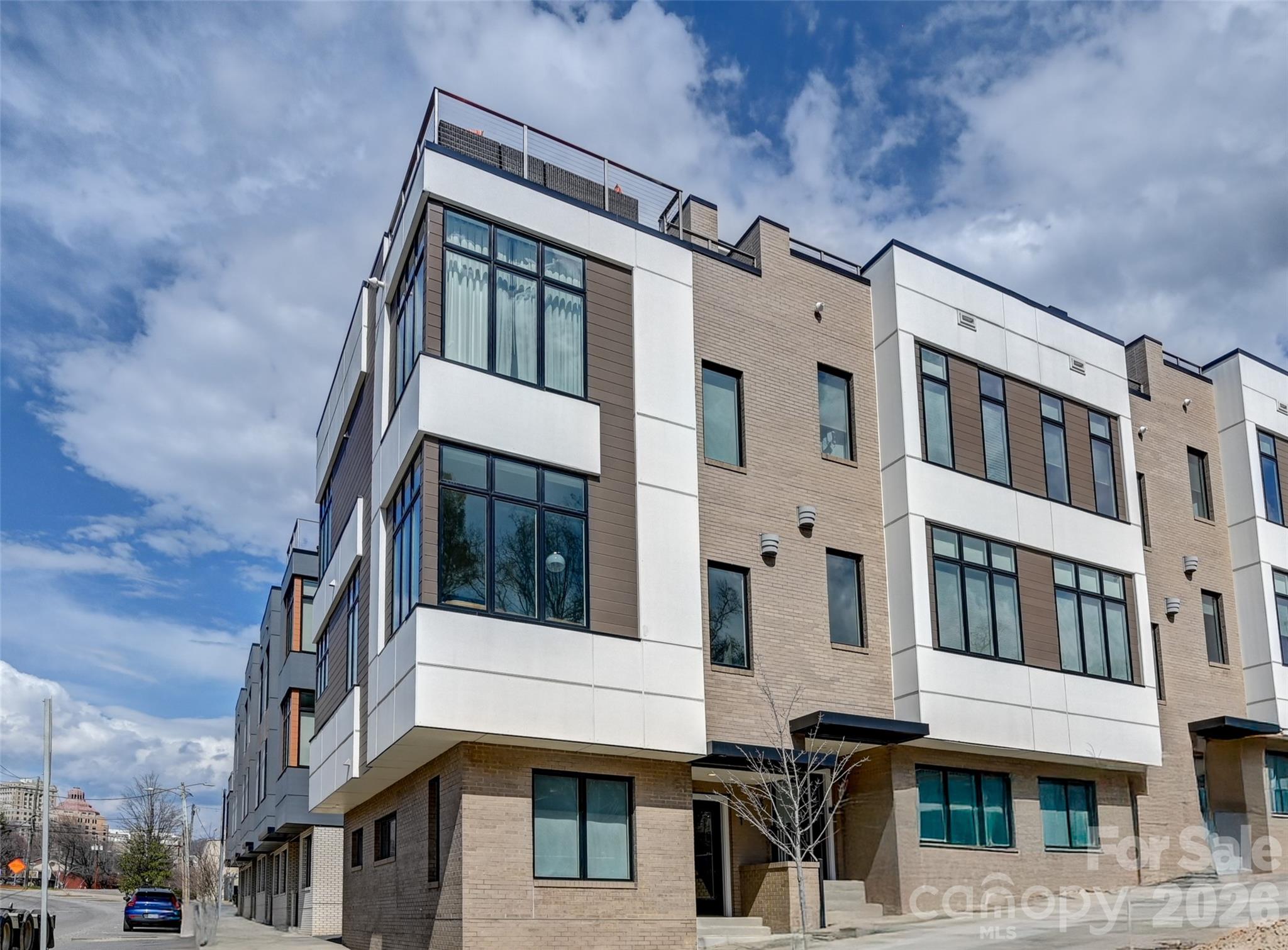 Your Asheville Address Awaits — Where Location Meets Lifestyle
Imagine owning a beautifully appointed, income-producing vacation home in the very heart of one of America's most celebrated cities. Nestled at the foot of Asheville's beloved historic ballpark, just a short way from the vibrant South Slope brewery district, two blocks to the energy of Downtown Asheville, and mere minutes from the grandeur of the Biltmore Estate and the breathtaking Blue Ridge Parkway — this is a location that simply cannot be replicated. This townhome is being sold fully furnished and turn key!
Inside, this light-filled corner townhome has been thoughtfully refreshed from top to bottom. New furniture, a refined contemporary stair runner, new artwork, and carefully curated light fixtures create an atmosphere that feels both elevated and inviting — equally suited for discerning short-term rental guests and your own personal retreat. Three spacious bedrooms, each with its own private ensuite bath, offer the kind of privacy and comfort that guests remember and return for. And the generous high-end stainless kitchen with large island is the perfect place to cook, gather, and enjoy company. 
The corner positioning of this unit is a rare advantage — flooding the home with natural light through dramatic oversized windows (treatments included!) and sharing only a single common wall for exceptional peace and quiet.
Outside on the roof you'll find the generous private terrace, where evenings come alive. A natural gas fire pit, plush sectional sofa, dining table, and gas grill set the scene for unforgettable outdoor living. Listen as the crowd roars at the ballgame below, then settle in for your own private fireworks show — a spectacular perk that never gets old.
Whether you're building a high-performing short-term rental portfolio or searching for a second home that truly has it all, this Asheville gem checks every box.