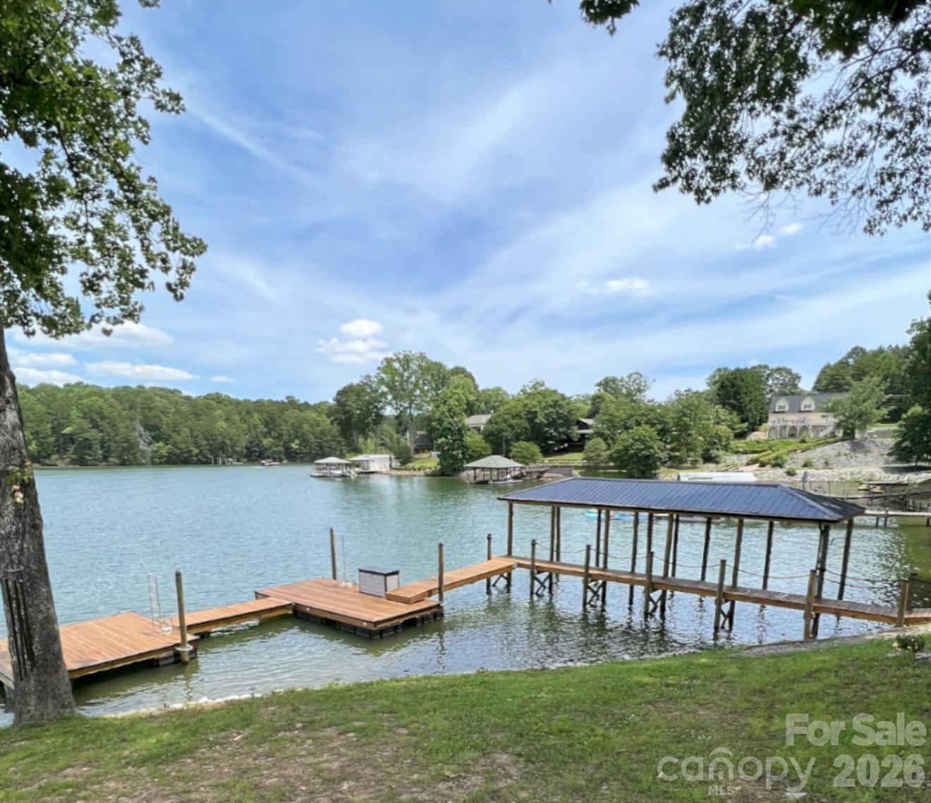 Price Improvement and ALL furnishings included for a turn key move in ready before the 4th of July Holiday weekend and start living the Lake Norman life!  Over 1 acre of Magnificent waterfront unrestricted land (NO HOA) with approx 217' of stabalized shoreline, a 40' covered fixed boatslip and additional floating dock.  Build your future home while you live in the 2024 build secondary home with 2 bedrooms a dedicated office or you could use this as a 3rd bedroom and 2 car garage.  No expense was spared during the construction.  The complete Kitchen Aid appliance package, Additional holiday dishes can be stored in the hidden cabinets in front of the bar stools, Tankless propane water heater, Sono's sound system indoor and out, complete wifi home and wifi at the dock, Lake fed irrigation pump installed, Power at the dock for a future lift, Smart home wiring, Generator transfer switch installed, 30amp Electric car charger in the garage and so much more.  You never have to worry if you have enough dock space for your friends and family.  Enjoy every night sitting on your covered porch or on the covered dock with a seating area.  Fall firepit nights with the peace and tranquility you have been searching for.  Bring your own builder or have a chat with the builder that constructed this wonderful open floor plan contemporary home.  Did we mention there is a former block boathouse that could be converted into a Jimmy Buffet style waterfront retreat.  Long range waterfront views from the primary bedroom, great room, kitchen and home office.  You can enjoy Lake Norman year round with deep water even when Duke energy brings the lake down during the winter months.  You can realize what you have vizualized in your new construction home or just enjoy the current home and the lay of the level land.  We've included a sample rendering of the primary home which was going to be constructed with the garage and front door on the street side with a wall of sliding glass doors for the bunk room, bathroom and hall. Basically flipping the garage level from back to front.  To access the home office or could be used as a 3rd bedroom, enter throught the garage.  Magnificent Waterfront views from the sliding glass door. Maximum building footprint is 50 x 60