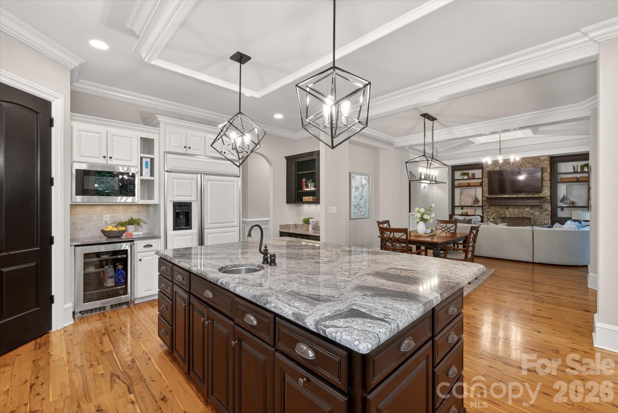 Built by the acclaimed New Traditions, this nearly 8,000 sq ft estate showcases timeless craftsmanship. The expansive floor plan offers gracious living and entertaining spaces alongside comfortable everyday areas, creating a home that is as elegant as it is livable. The Australian Cypress floors are a standout and so durable!  A dramatic two-story foyer with a sweeping staircase sets the tone, leading to beautifully proportioned formal living and dining rooms. The designer kitchen with professional appliances anchors the home with seamless flow into a large breakfast area and an impressive great room, creating an open-concept with expansive views of the outdoors! A private office on the main floor offers refined workspace with convenience and privacy. The upper level showcases four generously sized bedrooms, including a truly luxurious primary suite complemented by a private sitting room retreat, custom coffee bar, and a spa-inspired bath creating a sanctuary of relaxation. Spacious secondary bedrooms and a large bonus room provide flexibility for guests and recreation.  The lower level is a standout, delivering an extraordinary amount of dedicated lifestyle space. Large recreation room and large media room create the ultimate entertainment hub, complemented by a wet bar, and an additional guest suite with full bath. Completing the home is the beautifully designed outdoor living space off the main level, featuring a fenced backyard, patio, and a striking stone fireplace perfect for year-round enjoyment.  World class amenities - neighborhood pond, pool, lazy river, volleyball, playground, fitness center, tennis/pickleball and sport court.  Marvin Schools!