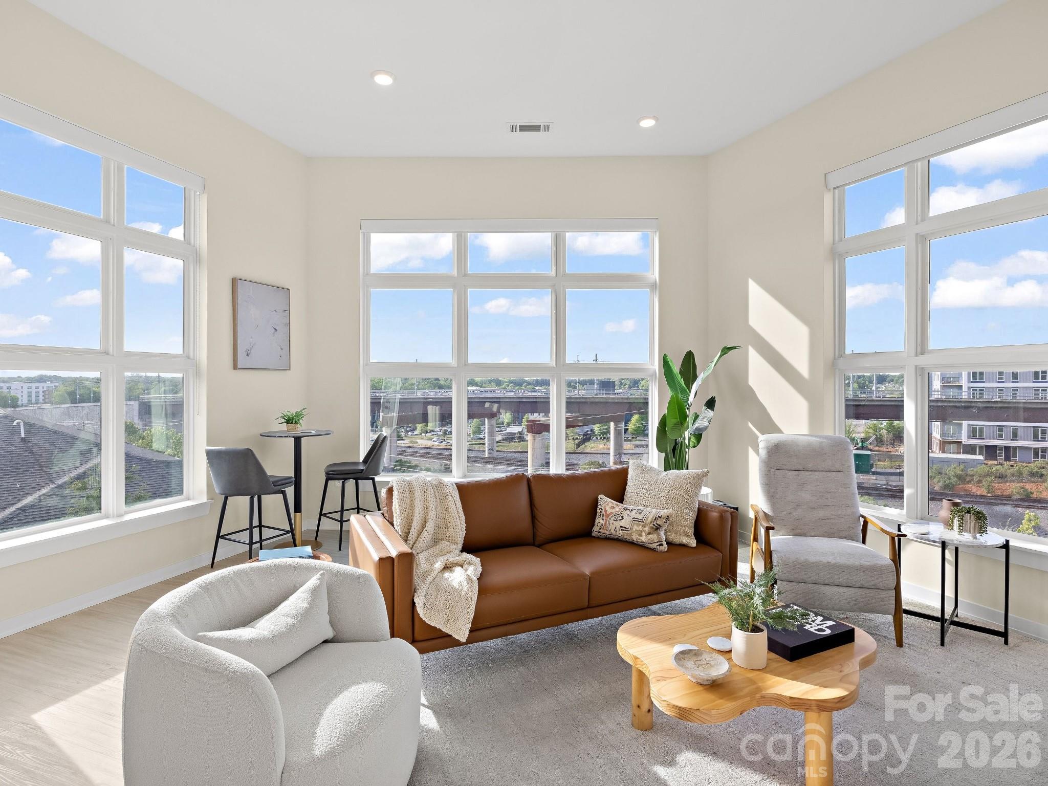 Welcome to a true 1 of 1 opportunity in the booming NoDa neighborhood, Charlotte’s hub for arts and entertainment. This penthouse unit with soaring 12’ ceilings floods every room with light, while walls of glass frame unobstructed western sunset and Uptown skyline views for miles. With no unit or building quite like this nearby or in development in the foreseeable future, this penthouse makes a tremendous investment in one of the most coveted neighborhoods within blocks of the Sugar Creek Lynx light rail station, providing a convenient commute to all that Uptown and beyond have to offer. Residents enjoy a 3,500 sq ft outdoor amenity terrace featuring fire pits, gas grills, and multiple seating and entertainment areas surrounded by mature landscaping. Inside, an open light-filled layout with modern furnishings available, custom blinds, a private balcony, high-end finishes, and almost 1,500 square feet of clean lines, and a penthouse footprint that simply doesn't exist anywhere else within miles. Additional features include a private storage unit and 2 assigned parking spaces. This is not a unit. This is a position — a rare convergence of architecture, location, and lifestyle that the Charlotte market may not see again.