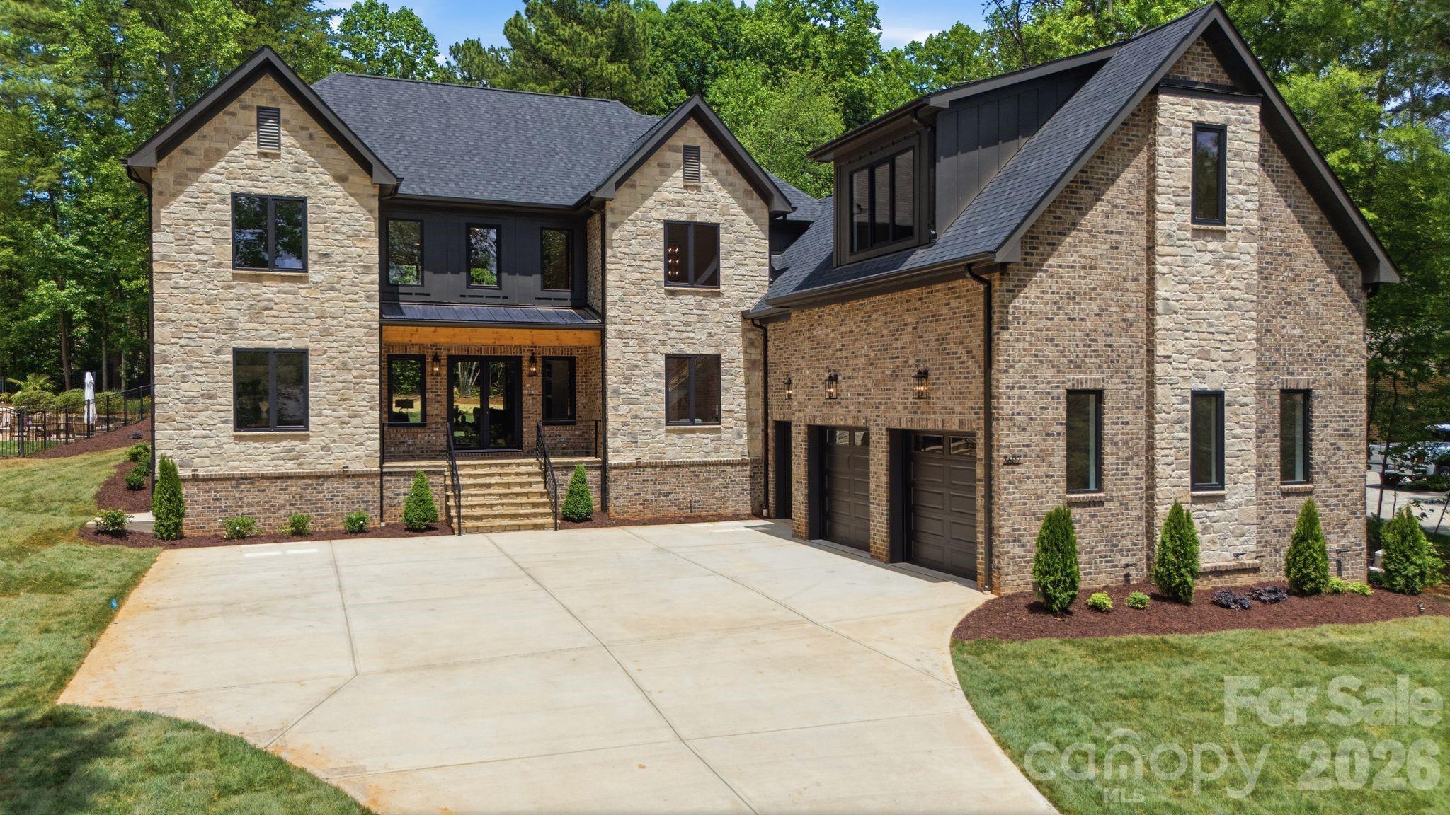 Set within the desirable Lakewood neighborhood, this custom home built by Prestige Homes combines timeless architecture with thoughtfully designed living spaces and elevated finishes throughout. A striking brick and stone exterior, large double door entry, and impressive curb appeal create a stunning first impression from the moment you arrive. Inside, beautiful white oak hardwood flooring carries throughout the home, complementing the warm modern design and open layout. The dramatic two story living room serves as the centerpiece of the home with soaring ceilings, abundant natural light, and a floor to ceiling stone fireplace that creates an inviting yet refined atmosphere. The kitchen was thoughtfully designed for both everyday living and entertaining, featuring custom white oak cabinetry, Taj Mahal countertops, a 48” stainless steel range, oversized island, and a spacious walk in pantry complete with a wall oven, microwave, and prep sink. The main level primary suite offers a private retreat with a spa like bathroom and dual walk in closets. Upstairs features four generously sized bedrooms, each with its own private ensuite bath, along with a large bonus room and loft overlooking the living room below. Laundry rooms on both the main and upper levels add additional convenience and functionality. Enjoy outdoor living from the covered rear porch overlooking the large backyard, all while being conveniently located near shopping, dining, and everyday conveniences. Thoughtfully designed with exceptional craftsmanship throughout, this home offers luxury living in one of the area’s most sought after communities.