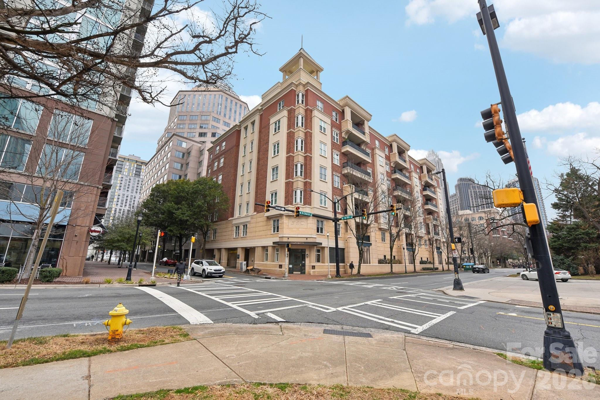 Experience upscale living in this beautifully updated PENTHOUSE suite nestled in the heart of Charlotte's historic Fourth Ward. Step into a spacious living area w/ 11-foot ceilings, gas fireplace, & panoramic windows, offering amazing top floor corner views. Lovely floor plan includes 2 bedrooms, each w/ a private full bath, amazing closet space, and dedicated office with french doors that invite privacy and natural sunlight. Unwind on your expansive balcony (with dedicated gas line and grill) overlooking the charming tree-lined streets of the Fourth Ward. Enjoy the dramatic sunsets every evening. Features neutral paint, new carpet, updated light fixtures & surround sound. Also includes TWO deeded parking spaces in the gated garage plus the convenience of a dedicated climate-controlled storage unit located across the hall on the same floor. Building has Fiber Optics! Located steps away from a plethora of local restaurants, cafes, professional sports venues and a performing arts center.
