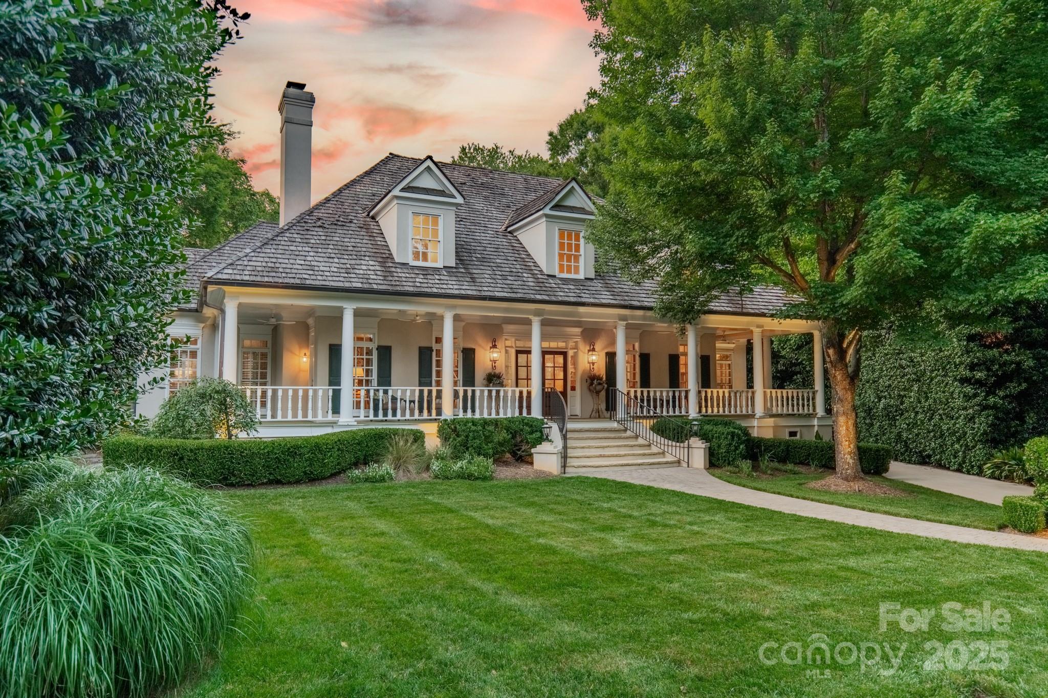 A rare opportunity to own a private retreat in one of Charlotte's most coveted neighborhoods. Tucked away on a .57-acre interior cul-de-sac lot, this stunning Low Country estate offers a main-level primary suite featuring dual walk-in closets & a spa-inspired bath. At the heart of the home lies the kitchen, appointed with exquisite custom cabinetry, professional-grade appliances & inviting breakfast room that opens effortlessly to indoor & outdoor living areas.  Elegant gathering spaces, including formal dining & living rooms-each with its own fireplace-plus a spacious great room anchored by a 3rd fireplace & expansive views of the backyard oasis. Upstairs you'll find 3 add'l bedroom suites & an oversized bonus room w/built-ins & a wet bar.  The outdoor living spaces are unparalleled-sparkling saltwater pool & spa w/ a natural waterfall, a fully equipped kitchen, generous dining & seating areas on the lanai, plus a screened porch & a full pool bath for added convenience.  Welcome Home!