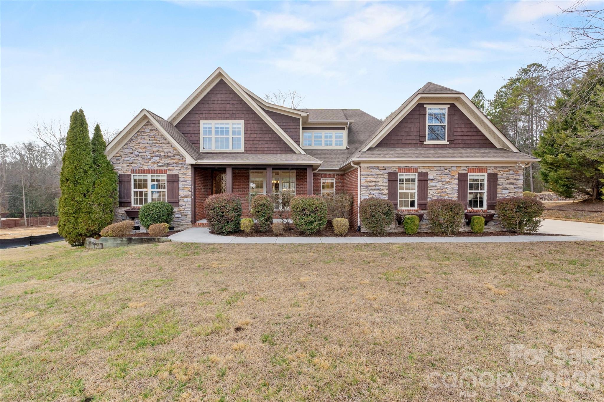 Custom-built brick and stone home on 1.08 wooded acres in the desirable Millstone Creek community, ideally located just minutes from Indian Land, Fort Mill, Ballantyne, and Waxhaw while offering a quiet, private setting surrounded by nature. With nearly 3,900 square feet of above-grade living space, this home was designed for both everyday comfort and exceptional entertaining.  

The main level lives like a ranch and features a vaulted great room with fireplace and beam detail, hardwood floors, formal dining room, breakfast area, and a chef’s kitchen highlighted by Viking appliances, custom cabinetry, stone countertops, gas cooktop, and walk-in pantry. Just off the living area is a stunning vaulted screened sunroom filled with natural light and overlooking the deck and wooded backyard — a favorite gathering space year-round.  

The private primary suite is located on the main level and offers a vaulted ceiling with wood beam detail, spa-style bath with Jacuzzi tub and separate shower, dual vanities, and an extraordinary walk-in closet that is nearly room-sized. A second main-level bedroom and full bath provide an ideal setup for guests or a home office. Main-level laundry with convenient access to the oversized garage adds to the home’s functional layout.  

Upstairs, a massive loft/flex space room of over 460 square feet with wet bar creates a second living area perfect for media, recreation, hobbies, or entertaining. Two additional spacious bedrooms with walk-in closets, a Jack-and-Jill bath with direct access from the bedrooms and hallway, and walk-out attic storage complete the upper level, making this home well-suited for guests, teens, or multi-generational living.  

Outdoor living spaces include a covered front porch, rear deck, wooded backyard with space for a pool, and access to the community pond. Additional features include county water, septic, natural gas, surround sound wiring, security system, and quality custom finishes throughout.  

Room sizes throughout the home are noticeably larger than typical production builds, with generous ceiling heights, detailed trim work, solid wood cabinetry, and hardwood flooring across most of the main living areas. The thoughtful design, custom finishes, and craftsmanship are evident in every space, creating a home that feels substantial, well-built, and timeless.  

From the great room to the kitchen, sunroom, dining area, and deck, the flow of the main level was clearly designed with entertaining and convenience in mind. Multiple gathering spaces allow for large events while still feeling warm and inviting for everyday living.  There is even a hot and a cold water faucet beside the garage for washing your car.  

Located in the Indian Land School District and positioned in one of Lancaster County’s fastest-growing areas, this property offers a rare combination of privacy, space, craftsmanship, and convenience.  

Square footage based on recent professional floor plan measurement.
