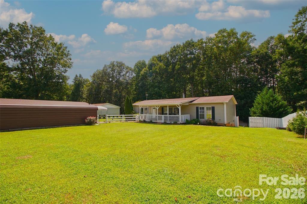 Welcome to 7010 Executive Circle in beautiful Denver! Nestled near Lake Norman with deeded lake access, this charming off-frame modular home offers the perfect mix of comfort, convenience, and peaceful living surrounded by nature. Featuring 3 bedrooms, 2 full bathrooms, and approximately 1,596 heated square feet, this home boasts a spacious floor plan with a large living room perfect for entertaining or relaxing after a day on the lake.

Recent updates include freshly painted interior walls and a freshly painted front porch, giving the home a clean and welcoming feel. Step outside to enjoy the above-ground pool with surrounding pool deck — an ideal setup for summer gatherings and outdoor enjoyment. The fenced front yard provides additional privacy and space for pets or recreation.

Additional features include a detached carport with ample parking for multiple vehicles, boats, or outdoor equipment, plus a security system integrated with smoke detection for added peace of mind. The home is also equipped with a water purification system including a water softener and UV light filtration system.

Whether you're searching for a full-time residence, vacation getaway, or investment opportunity, this property offers the perfect place to settle down and enjoy the laid-back Lake Norman lifestyle.