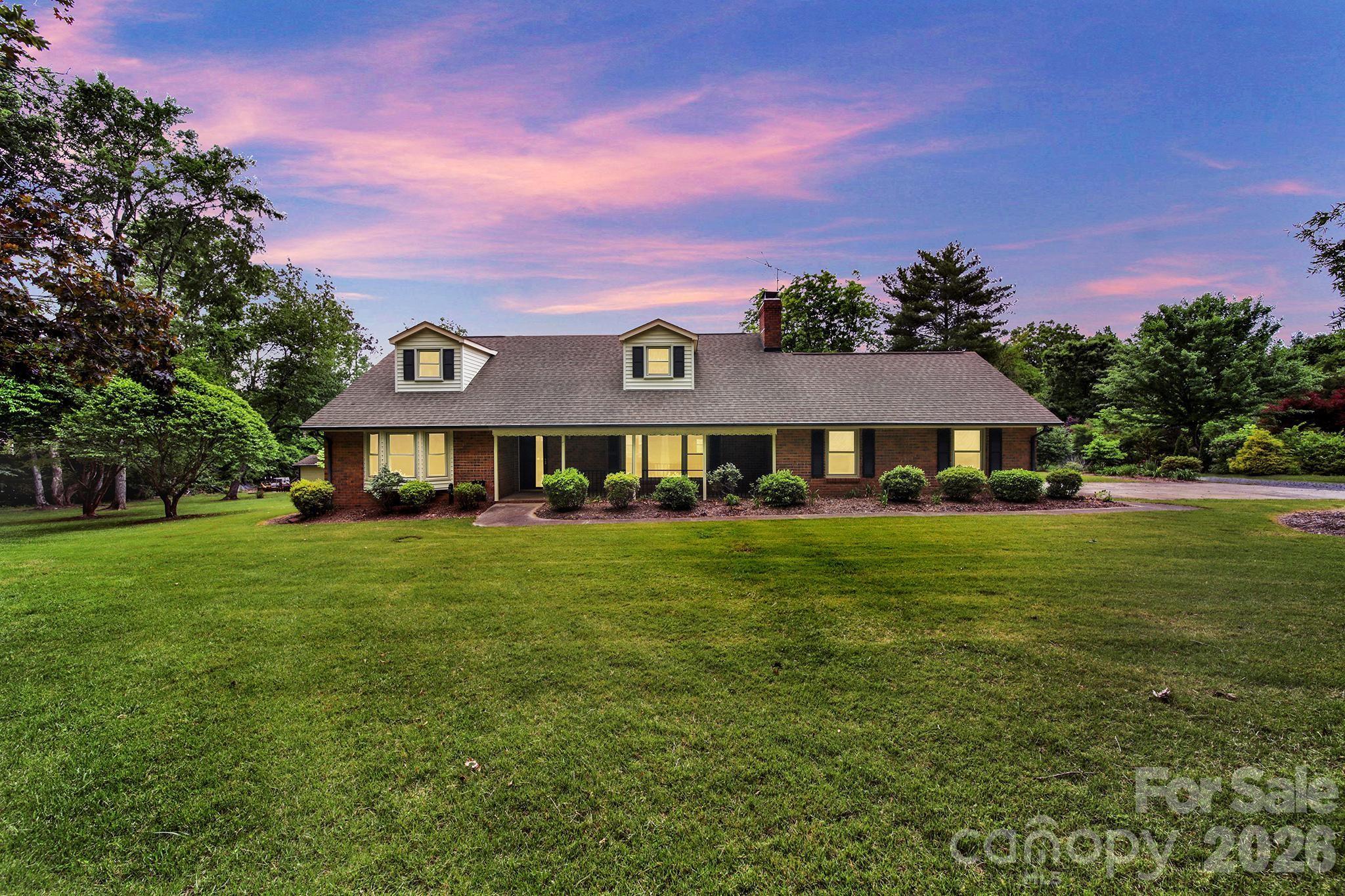 Spacious brick 1.5-story home with 2857 sq ft situated on 5.12 acres, featuring secondary living quarters and almost 1600 sq ft of workshop/outbuilding space. Located  in the growing Caldwell / Tom Query corridor with a Charlotte address in Cabarrus County. This 4-bedroom, 4-bath property offers a unique blend of space, functionality, and opportunity.   A welcoming front porch leads into a comfortable living room featuring a fireplace. and built-ins. The kitchen includes a stainless steel wall oven, convection microwave, dishwasher and granite countertops. Large second living quarters provide excellent flexibility for multi-generational living or guest space. Most of the acreage has already been cleared, offering endless possibilities for outdoor living, recreation, or future expansion. Property is currently on well and septic, with water and sewer available. Conveniently located near shopping, dining, and commuter routes while still offering privacy and room to spread out. Property being sold “As Is.”