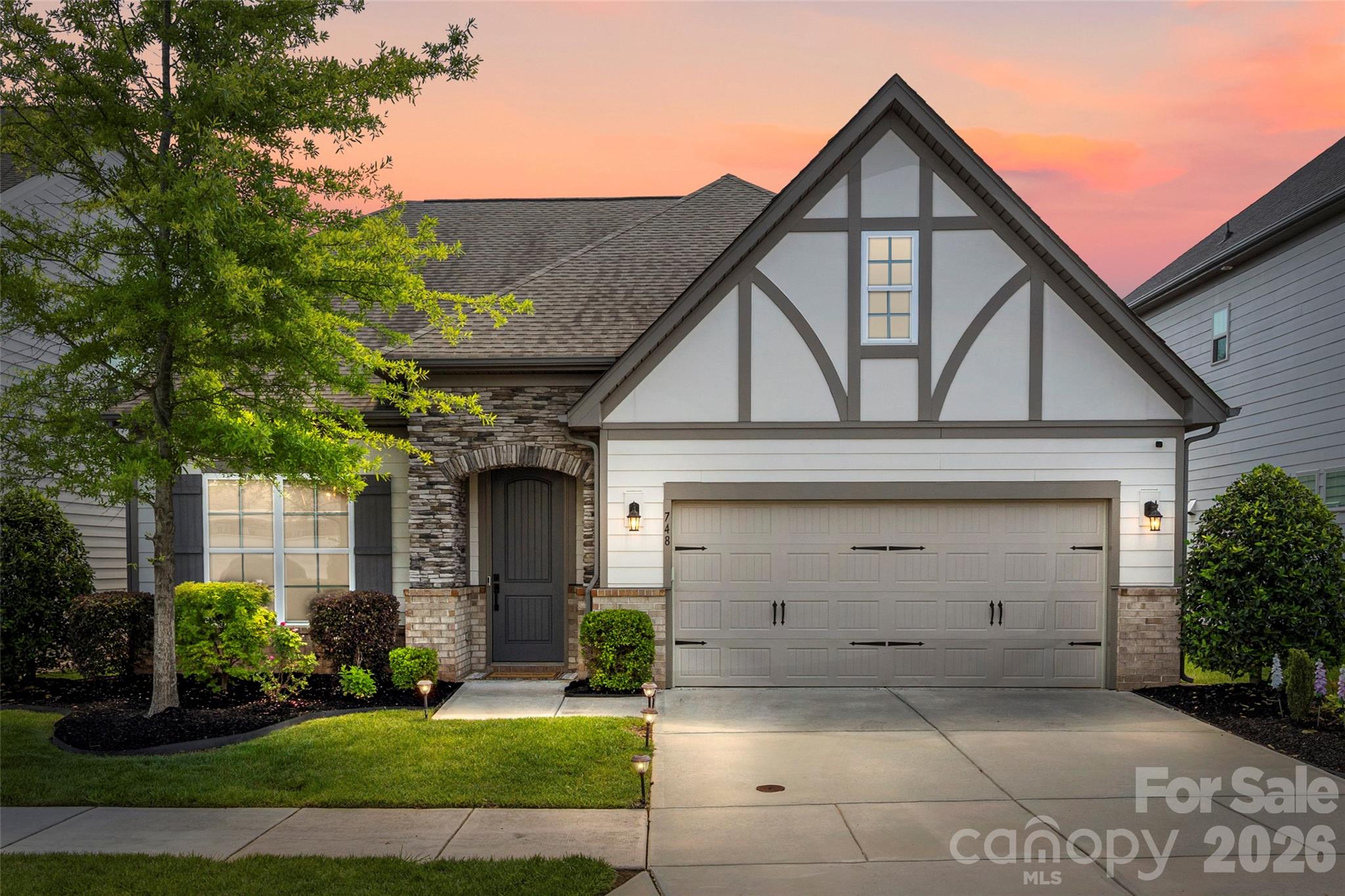 There is no shortage of show-stopper finishes at this designer home, with primary suite on the main floor! From the moment you enter through the covered front porch, you are welcomed by hardwoods throughout the main level and upstairs loft. Expansive office with French doors and tray ceiling, plus a great room centered around a stacked stone gas fireplace. The open floor plan features a chef’s kitchen with massive island, wall oven, gas cooktop with vent hood, quartz counters, farmhouse sink, designer backsplash, and oversized pantry. Dining area overlooks the beautifully landscaped backyard, screened porch, and generous paver patio, perfect for entertaining. Main-level primary suite includes tray ceiling, dual vanities, soaker tub, and walk-in shower with floor-to-ceiling tile and bench. Additional main floor features include half bath, built-in drop zone, and laundry room with cabinets. Upstairs offers a spacious loft, two walk-in attic spaces, two secondary bedrooms with walk-in closets, and full bath with dual sinks. Additional features include irrigation on all sides, security system, motion sensor lighting, designer fixtures, termite bond, plus refrigerator, washer, and dryer convey. Located in desirable Oakland Pointe with sidewalks and street lights, just minutes from historic downtown Fort Mill and Walter Elisha Park, known for the town’s annual Fourth of July cannon tradition, as well as the Anne Springs Close Greenway Blue Star Trail, public tennis/pickleball courts, baseball fields, and more. With award-winning schools, and low SC taxes, Welcome Home!