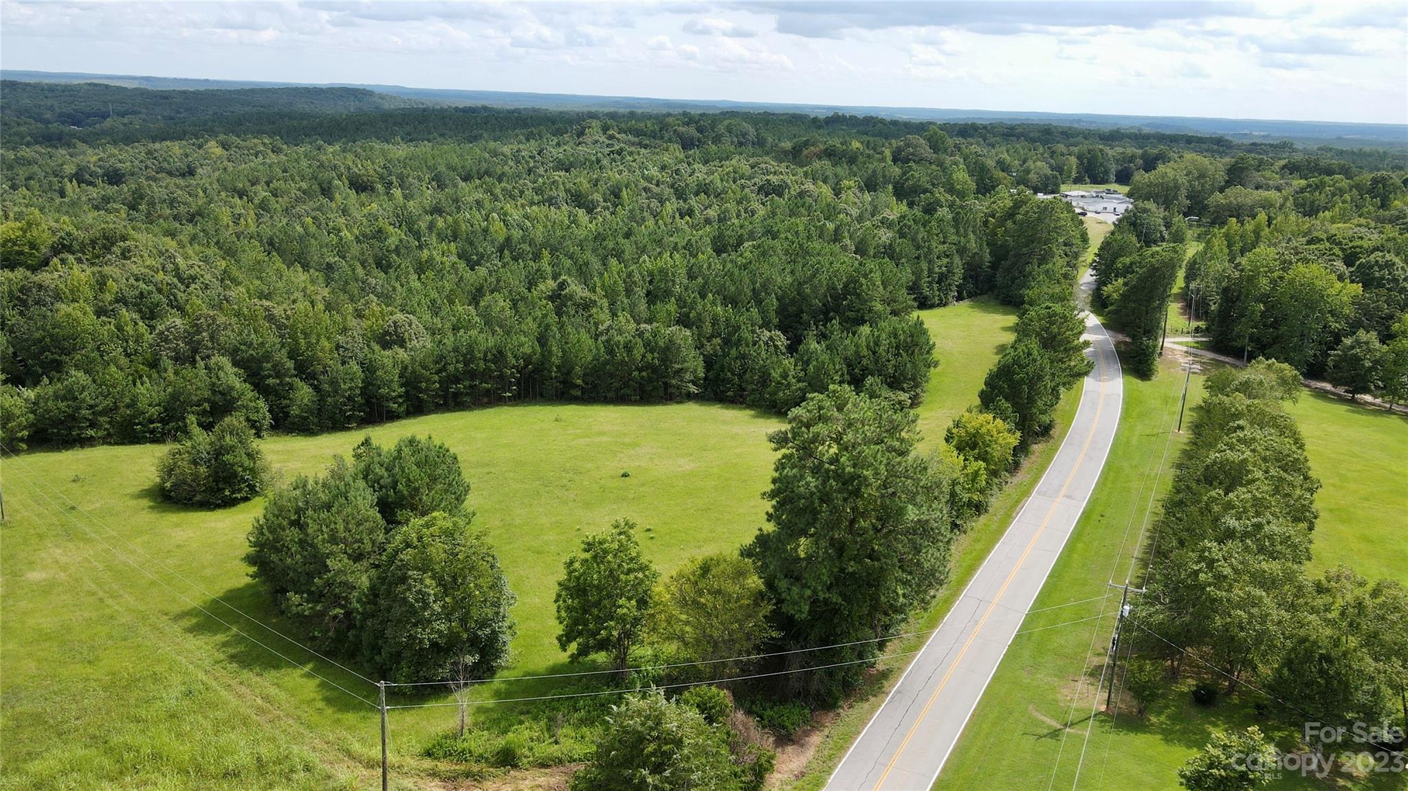 Discover a rare opportunity to own a piece of paradise in Hickory Grove. This 87-acre property has a blend of untamed wilderness and open spaces, offering endless potential for your dreams to flourish. With over 2000 feet of road frontage on Hwy 97 and more than 2500 feet of stream frontage, this property is a haven for nature enthusiasts. The gently rolling topography of this land provides a variety of uses, from creating your own private retreat to enjoying exhilarating hunting escapades. The property provides an array of potential build sites, allowing you to design your ideal home amid the landscape. Deed restrictions will be placed at closing, ensuring the land remains free from manufactured home developments. The property has one easement to an occupied dwelling. Located just 1 hour from the vibrant city of Charlotte, 40 minutes from Rock Hill, and 30 minutes from Chester, you'll enjoy the best of both worlds – the tranquility of rural living with access to urban amenities.