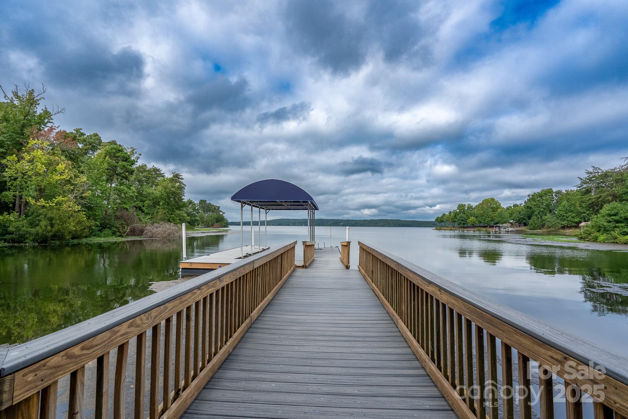 Welcome to this truly spectacular lakefront dream home in the sought-after Old North State Club community! Enter onto the property via the private, wooded circular drive to be wowed. The attention to detail in this exquisite home is unmatched. The chef's kitchen with state-of-the-art appliances is open to a spacious Great Room with stacked stone fireplace and unique roofline designed to let in maximum natural light. The elegant primary includes fireplaces in the bedroom as well as the adjoining light-filled study and an incredibly lavish bath. Outdoor entertaining couldn't be easier on the gorgeous back porch with custom stone built-in grilling station, but the circular screened-in porch with panoramic lake views steals the show. Plenty of storage, a full laundry room and an attached garage for convenient parking. Walk down the paver path to your private pier to take advantage of all the water activities Badin Lake has to offer and join the Old North State Club for championship golf, dining, courts, pools and much more.