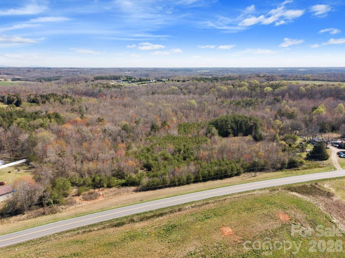 Bring your vision to life and build your dream-home on this huge 16.50 acre property located at 879 E Memorial Hwy! Two streams, rolling hills, and your own private wooded forest invite deer and other wildlife to explore your new back yard. This will make an excellent, large, private estate lot for a custom single family home. Site-built, modular/pre-fab, and mobile homes are all welcome in this zoning. This property has access to county water, electricity, and comes with a passing perc test good for a standard septic system. An abundance of suitable soils were found across this large property, giving you a wide range of options for home placement and bedroom count! The Parcel ID is 4789-99-7226. Located just 1 hour from Charlotte, 22 minutes from Statesville, 34 minutes from Winston-Salem, and 1 hour from Greensboro, this property offers a peaceful rural setting with easy access to major markets.