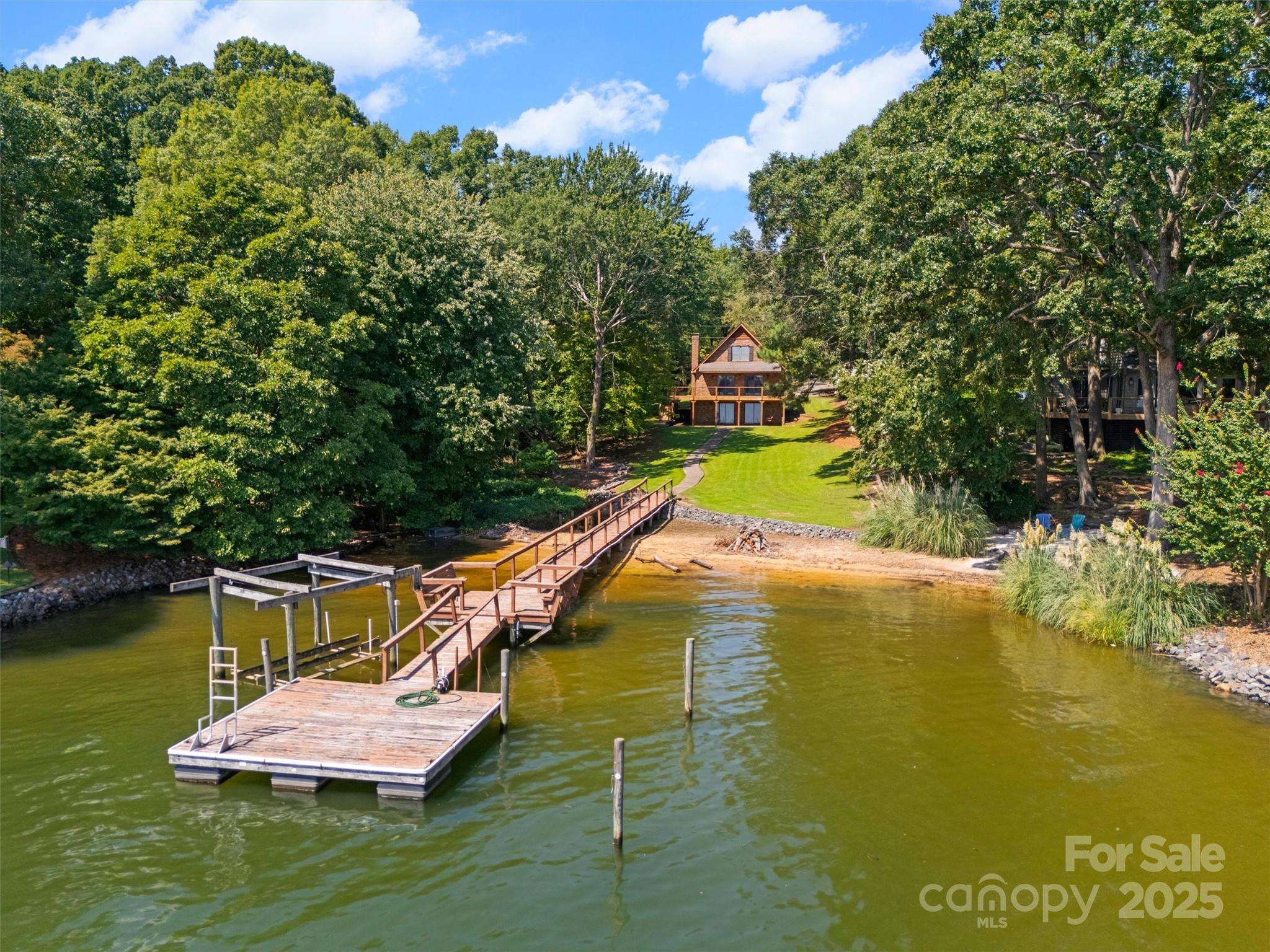 Location, location, views! If you're looking for a big water lot that is in the heart of Lake Wylie this is it! Big water main channel lots are becoming a rare commodity in the current waterfront market. Almost as special as the big water views is the sandy beach perfect for relaxing and swimming. There is a dock and lift already in place so bring your boat! The house is true brick construction with a newly built deck overlooking the lake. There is a detached carport that has additional storage. Situated within Old Concord allows you to experience the perfect blend between community and privacy. Whether your looking to build your dream home or just enjoy a waterfront retreat this one is a must see.