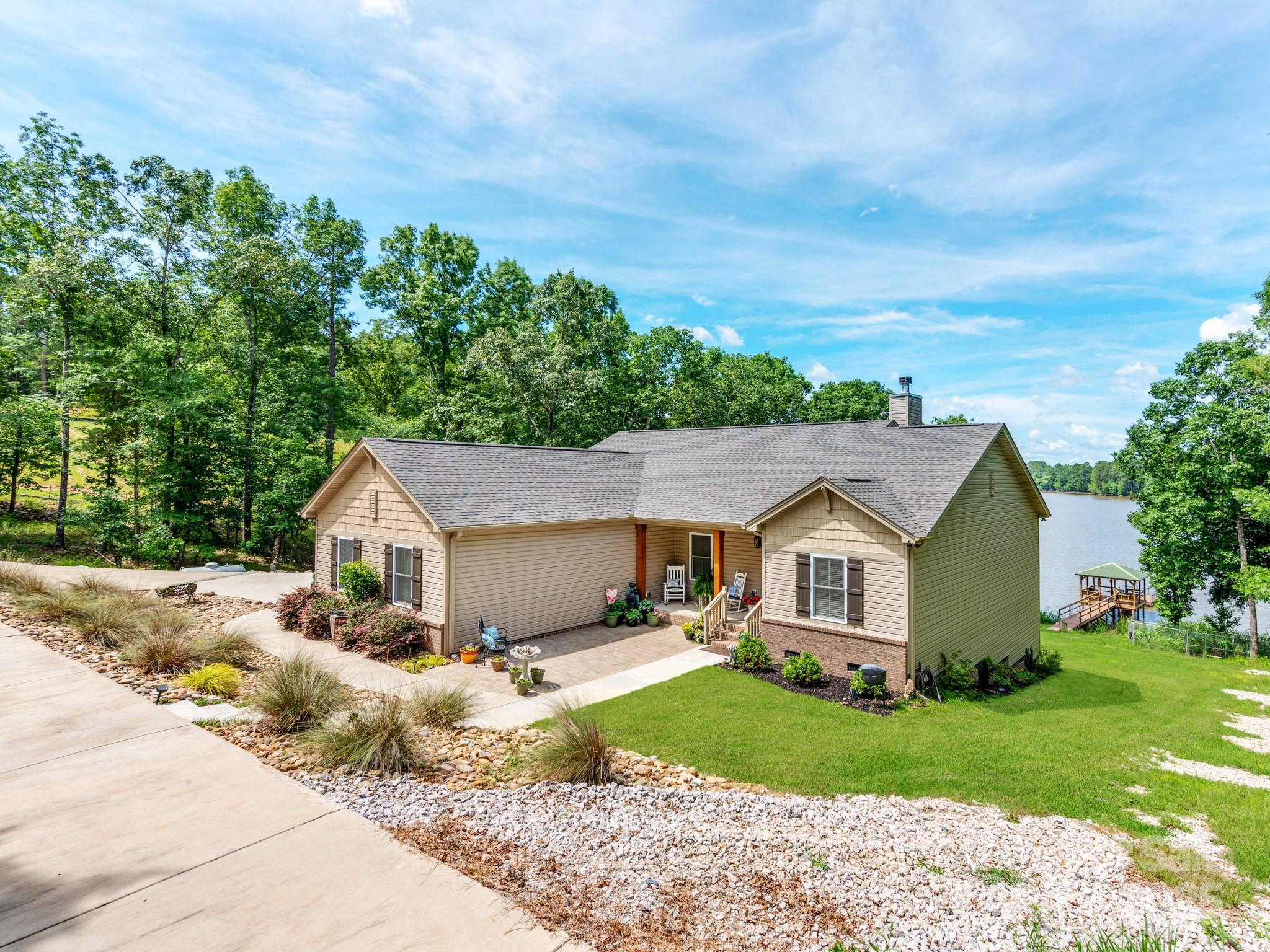 Back on Market No Fault to seller! Stunning, custom-built 3 bed, 2 bath ranch home on the main-channel, deep water shores of Lake Wateree. Step inside to find cathedral ceilings with beautiful beams and a striking floor-to-ceiling gas stone fireplace. The gourmet kitchen features quartz countertops, a 9 ft island, and a 36" 6 burner gas stove. Both bathrooms boast extra tall granite countertops, while the primary suite offers a full tile shower & spacious walk-in closet with an additional safe closet. The large pantry and laundry room add storage and convenience. The whole back wall of the home is adorned w/ expansive windows, showcasing the breathtaking lake views. Enjoy the stunning scenery from the screened-in porch & grilling deck, complete with a gas line for convenience. The permitted gazebo-style dock, equipped with benches, electricity and water, is perfect for entertaining or relaxing by the lake. A designated 30x20' garden area, and enclosed with a 6 ft fence & concrete walls