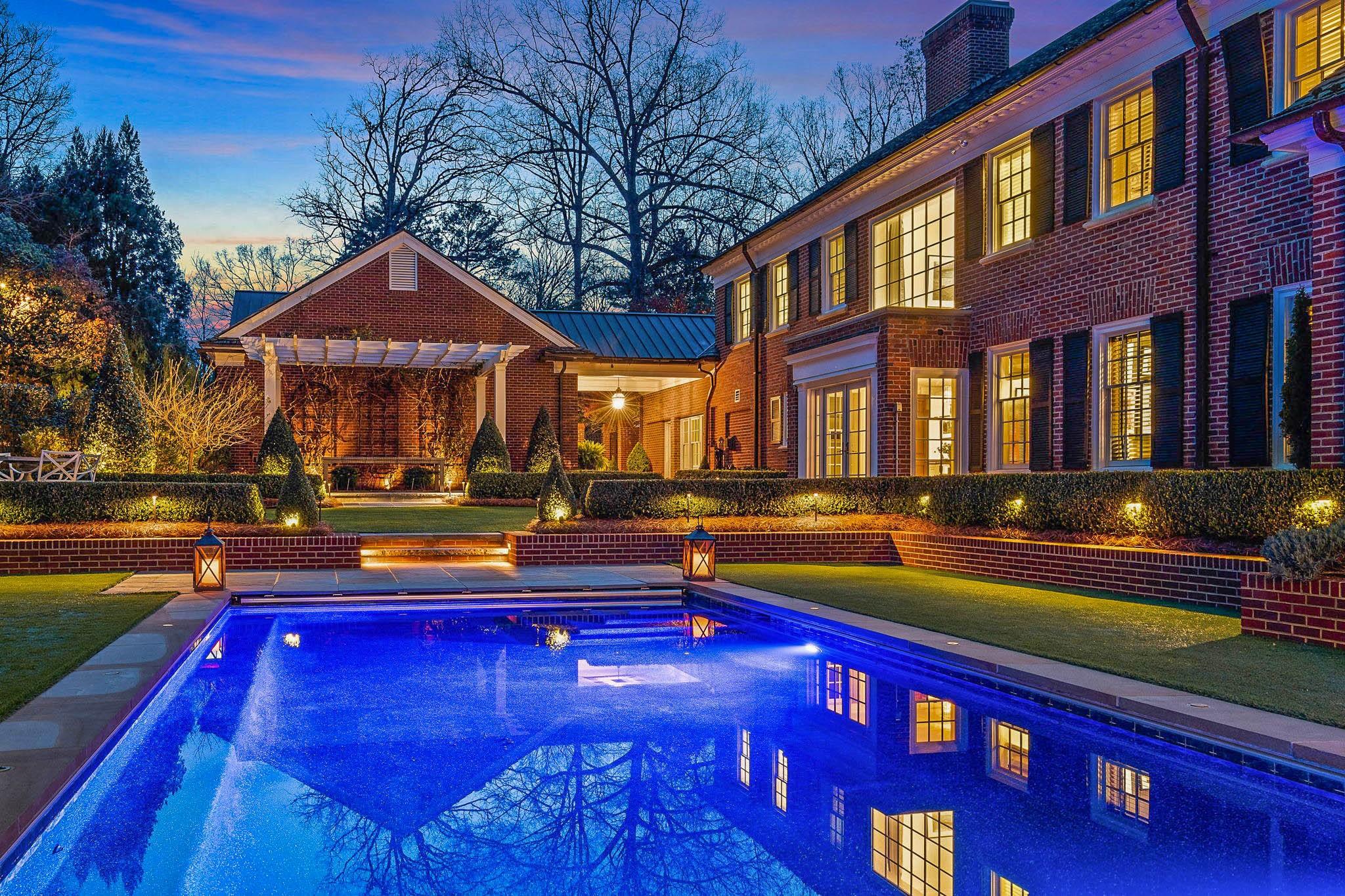 The Heavner-Williams home is a 1947 Georgian Revival masterpiece located in The Pines, within walking distance to downtown Hickory and Lake Hickory Country Club. Nestled onto a wooded 1.09 acre lot, this historic gem offers a stunning landscape and the finest quality interior spaces around. After a 3-1/2 year renovation by Glaze Construction, the project was featured in Traditional Home magazine showcasing the top quality craftsmanship found throughout. The main level features a mix of formal & informal areas, perfect for entertaining, plus a stunning fully tiled kitchen with original walk-in cooler (now used as a pantry) & a restored 1936 Magic Chef gas range. Upstairs, you'll find three bedroom suites, including a primary suite with the most alluring primary bath imaginable. The third floor offers a 4th bedroom suite with full bath. Outside, the rear terrace offers a gunite pool, cabana, thoughtfully designed grounds, triple garage, & the utmost sense of privacy. Truly one of a kind.