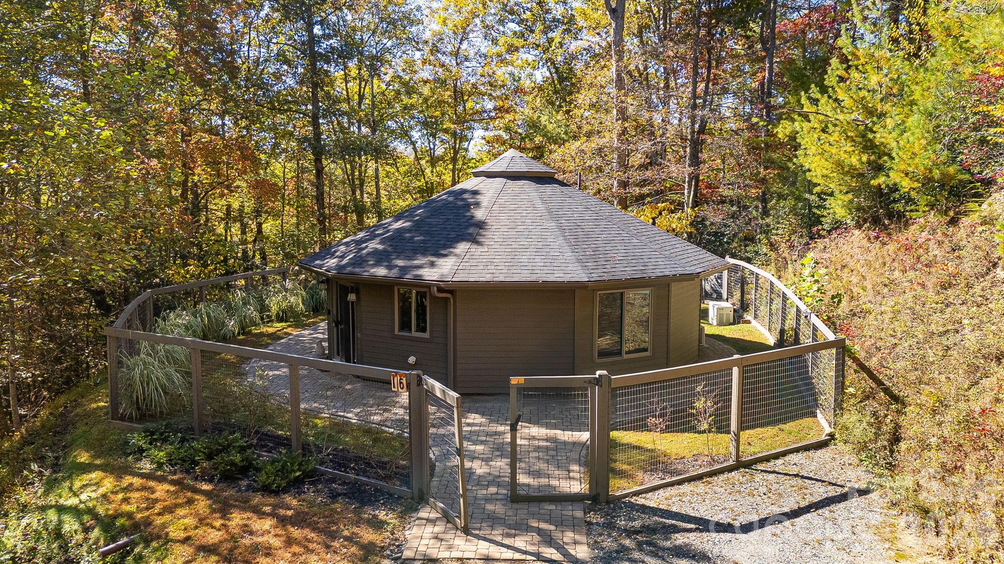 Escape to serenity with this immaculately maintained custom Deltec High Energy Efficient Home on 5.5 beautiful and private wooded acres minutes from Hot Springs. Sold turnkey - all furnishings, appliances, dishes and linens included. This one-of-a-kind Luxury Fishing retreat combines mountain living with modern comforts, featuring stunning woodwork, vaulted ceilings, custom built-ins, custom polished concrete, 600 foot well, mid-century pieces and windows that bring the beauty of nature indoors. Direct private access to Laurel River. Outside, immerse yourself in the lush grounds, with hiking trails, scenic views, and plenty of space for outdoor activities such as trout fishing in the famous Laurel River. Enjoy amazing views from your back porch and fire-pit. An easy, 15 minute drive to Hot Springs, 25 minutes to Greeneville TN, and 40 minute drive north of Asheville. Land and area has been spared from any major hurricane damage.