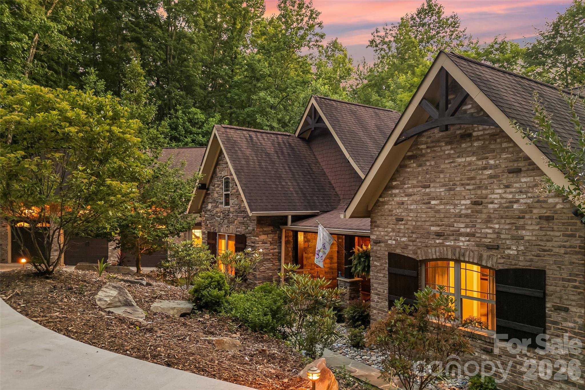 Experience the ease of one-level living in this exceptional lakefront retreat, perfectly positioned in a private cove designed for relaxation, recreation, and unforgettable entertaining. Exterior is charming with Old Carolina brick, Hardisiding and stone accents.  A welcoming covered front porch sets the tone for the warm and inviting interior. Inside, the spacious great room showcases soaring beamed ceilings and flows seamlessly into the chef's kitchen, creating an ideal gathering space for family and friends. Just beyond the kitchen, a quiet reading nook or breakfast room offers the perfect place to enjoy morning coffee while taking in peaceful views. The open dining area completes the heart of the home, providing generous space for everyday living and special occasions. There is also a built in bar and entertainment area with a distinctive bourbon barrel stave accent wall that creates the ultimate gathering spot. Designed to embrace indoor-outdoor living, expansive doors open to a spectacular flagstone patio featuring a stunning wood-burning stone fireplace and an entertainer's dream outdoor kitchen complete with a gas grill & electric smoker.  The thoughtfully designed main level includes a spacious primary suite with a private bath, a second bedroom that also serves perfectly as a home office, an additional guest bedroom, and a well-appointed hall bath. A large laundry and mudroom offers exceptional functionality and connects to the oversized three-car garage, complete with utility sink, freezer, and abundant storage. Upstairs, guests and family will appreciate the finished recreation room, additional bedroom, full bath, and convenient kitchenette, creating an ideal private retreat or multi-generational living space. Outdoor enthusiasts will appreciate the included Hurricane deck boat and utility Gator, making lake adventures and property access even more convenient. Take the easy path to the two slip floating dock with lift.  With incredible storage throughout, premium outdoor amenities, and a layout that blends everyday comfort with luxury entertaining all on one level, this lakefront property offers an extraordinary lifestyle where every day feels like a vacation.