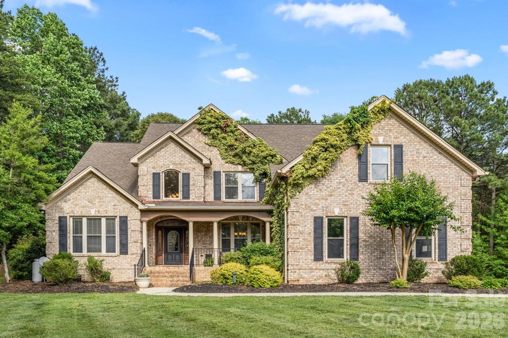 Beautiful full brick home nestled on a quiet cul-de-sac in a smaller, peaceful subdivision just moments from the growing conveniences of Sherrills Ford, including Publix, restaurants, shopping, and everyday amenities. Thoughtfully designed with quality craftsmanship and timeless architectural details, this exceptional home offers year round water views from the front of the property and a spacious covered front porch perfect for rocking chairs and enjoying the tranquil setting. A striking leaded glass front door welcomes you into an impressive foyer featuring rich hickory hardwood flooring throughout the main level, extensive crown molding, elegant arches, and custom bullnose corners. The dramatic great room showcases a soaring cathedral ceiling and beautiful gas fireplace, creating an inviting space for both everyday living and entertaining. The adjoining dining room flows seamlessly into the spacious kitchen, which offers gorgeous cabinetry, granite countertops, stainless steel appliances, abundant prep space, and an ideal layout for hosting family and friends. A private main level office with French doors and a trey ceiling provides the perfect work from home space or flexible living area. The main level primary suite serves as a peaceful retreat with a trey ceiling, large walk in closet, and spa inspired bath featuring dual vanities, a soaking tub, oversized shower, and generous storage. Upstairs, three additional bedrooms, two full baths, a large bonus room, and a dedicated exercise room provide exceptional flexibility for a media room, fitness studio, hobby space, guest accommodations, or multi generational living. Step outside to enjoy the beautifully secluded backyard complete with a fire pit gathering area and a 7 person saltwater hot tub, creating the perfect setting to relax, entertain, or unwind after a day on Lake Norman. Whether enjoying morning coffee on the front porch, evenings around the fire, or quiet nights under the stars, this home offers a lifestyle centered on comfort and making lasting memories. Ideally located near Lake Norman marinas, parks, boating, walking trails, dining, and shopping, this exceptional property offers the perfect balance of peaceful surroundings and everyday convenience. With spacious living areas, quality finishes, and an outstanding location, this is a rare opportunity to own a truly special home.