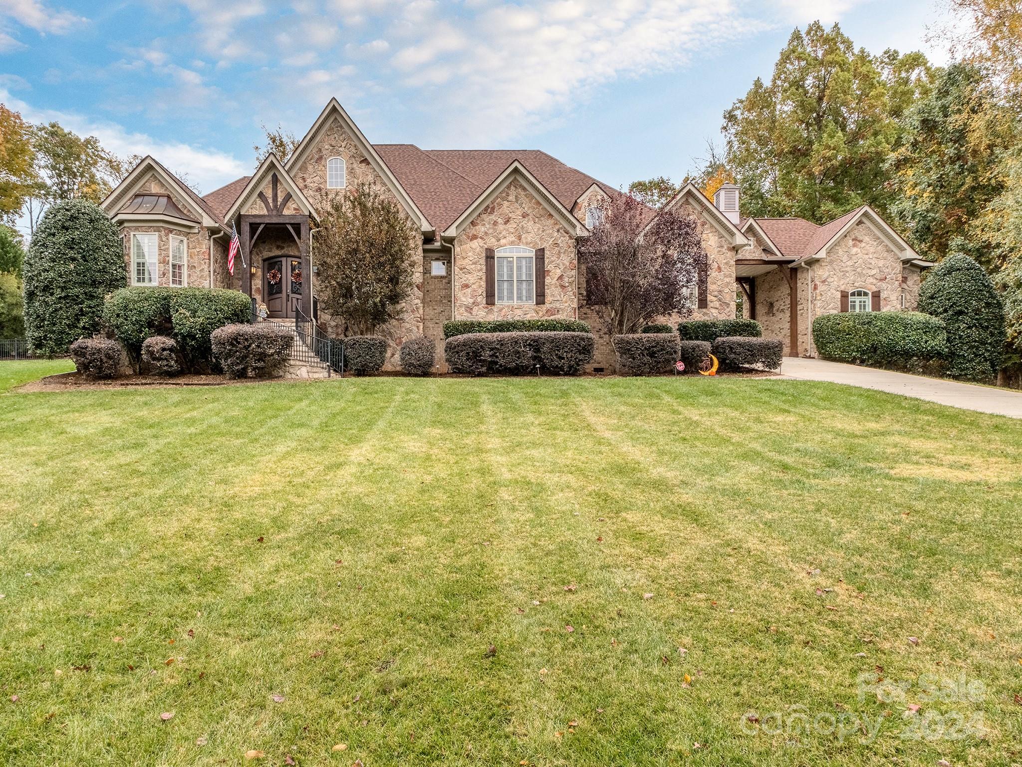 Gorgeous 4 bedroom, 1.5 story home located in Lake Wylie on 2.53 acres with 2 entrances, custom finishes throughout and no HOA! All bedrooms on the main floor with bonus upstairs. This home features an updated kitchen with newly painted cabinets & hardware, counter height bar & wainscoting, quartz countertops & backsplash, under-counter lighting, new sink and disposal.  The backyard oasis includes a gas fire pit, a custom gunite pool and spa flowing down an 8 foot waterfall and surrounded by a resurfaced pool deck and a beautifully landscaped fenced yard with irrigation system. Some unique features to this home include a sports field with a paved cul-de sac, a two car garage, an additional one car garage attached by the porte-cochére and an RV sized garage that can easily be converted to an entertainment area. Additional enhancements include new garage doors with MyQ camera/smart system, 2 new HVAC systems, new pool equipment with smart system controls. You don't want to miss this one!
