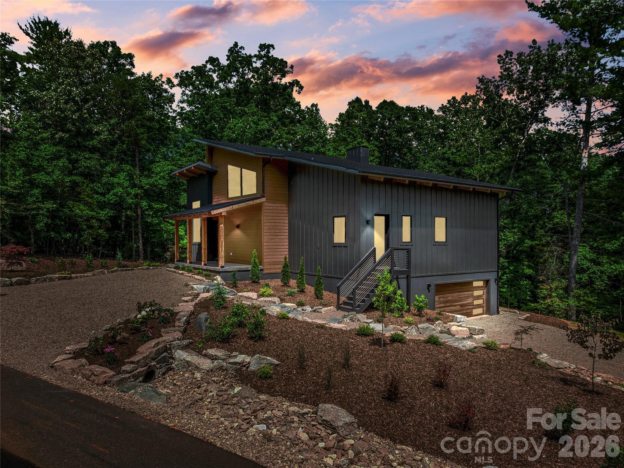 Priced at almost $20k below tax value and nestled inside the gates of the desirable Lakewood community you will find this custom built Mountain Modern masterpiece. The exterior offers ample yard space, fire pit & manicured landscapes nestled in a beautiful wooded 2.68 acres. Covered front & back porches allow you to take in the peaceful nature offered at this private oasis. Upon entering the home you will find 28' ceilings, high end finishes & meticulous attention to detail at every turn. Large custom windows throughout bring in ample amounts of light & wooded views. At over 3000sf this home offers ample space for entertaining & features a wet bar, dog wash & 2 bonus rooms. This home is ideal for a primary oasis, 2nd home & is also able to be used as a short term rental! Have your vacation home paying for itself! All of this while being only 2 miles to vibrant downtown Marion & 4 miles to Lake James. Ski resorts, Asheville & several airports all within short commutes. This home is a must see to fully appreciate and priced to sell! More info at singlepointmedia.hd.pics/1180-W-Lake-Rd/idx