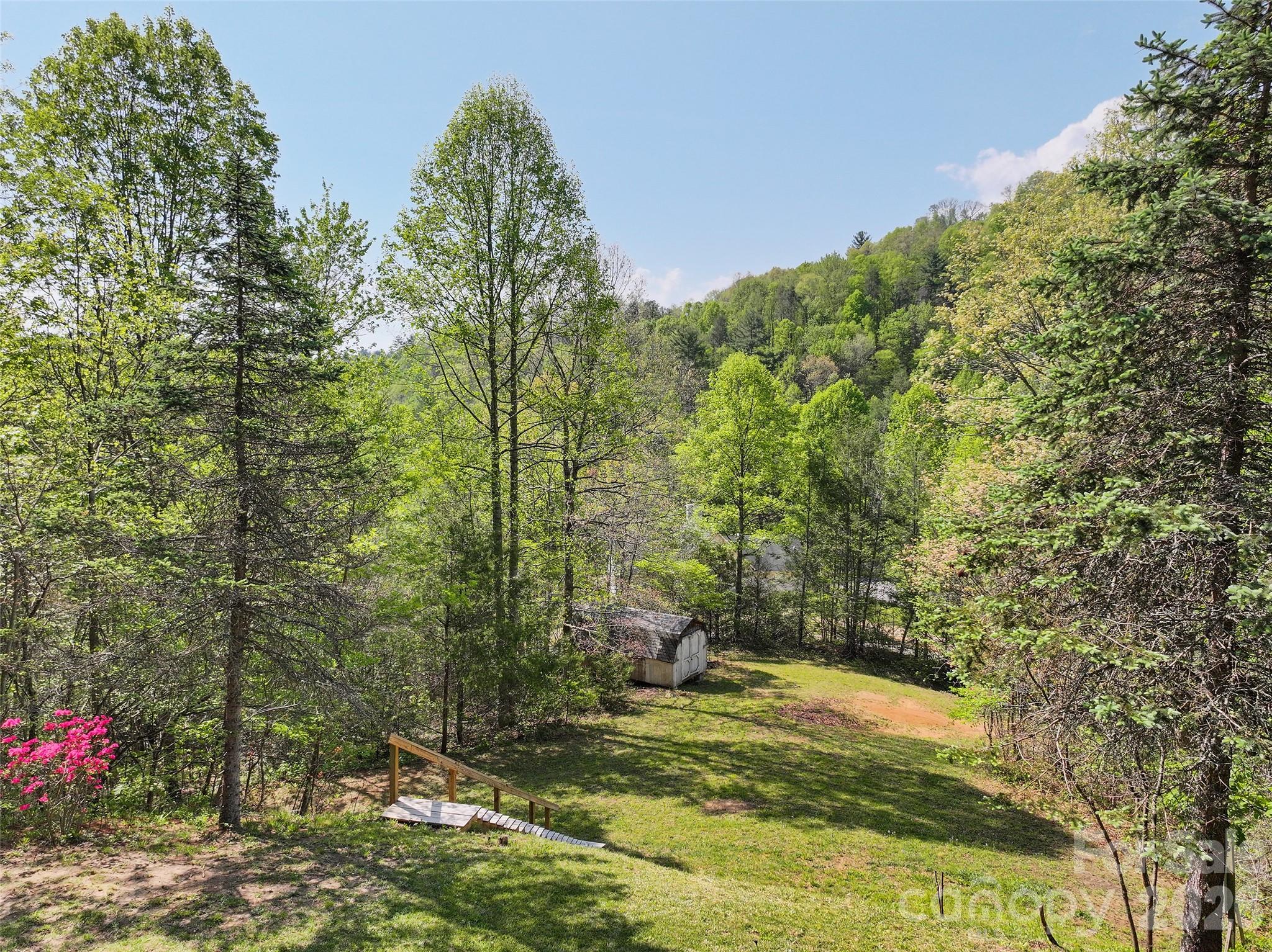 Tucked into the trees on 2.44 acres, this recently renovated 2 bed / 2 bath feels like your own little mountain escape. Light, airy, and truly move-in ready; this is the kind of home that just feels easy the moment you walk in. Inside, the open layout is bright and welcoming, with vaulted ceilings and a natural flow from the living space into the kitchen. Crisp white cabinetry, stainless appliances, and a spacious island make it as functional as it is inviting. Outside is where it really shines. A great front porch to start and end your day, a spacious yard to spread out, and wooded surroundings that create a quiet, peaceful setting. You’ll hear the birds and maybe spot a few deer, not traffic. Whether it’s slow mornings with coffee, afternoons in the hammock, or evenings under the stars, this property was made to be enjoyed. Simple, refreshed, and full of mountain charm. List of upgrades you will want to see - NEW HVAC and water filtration system.