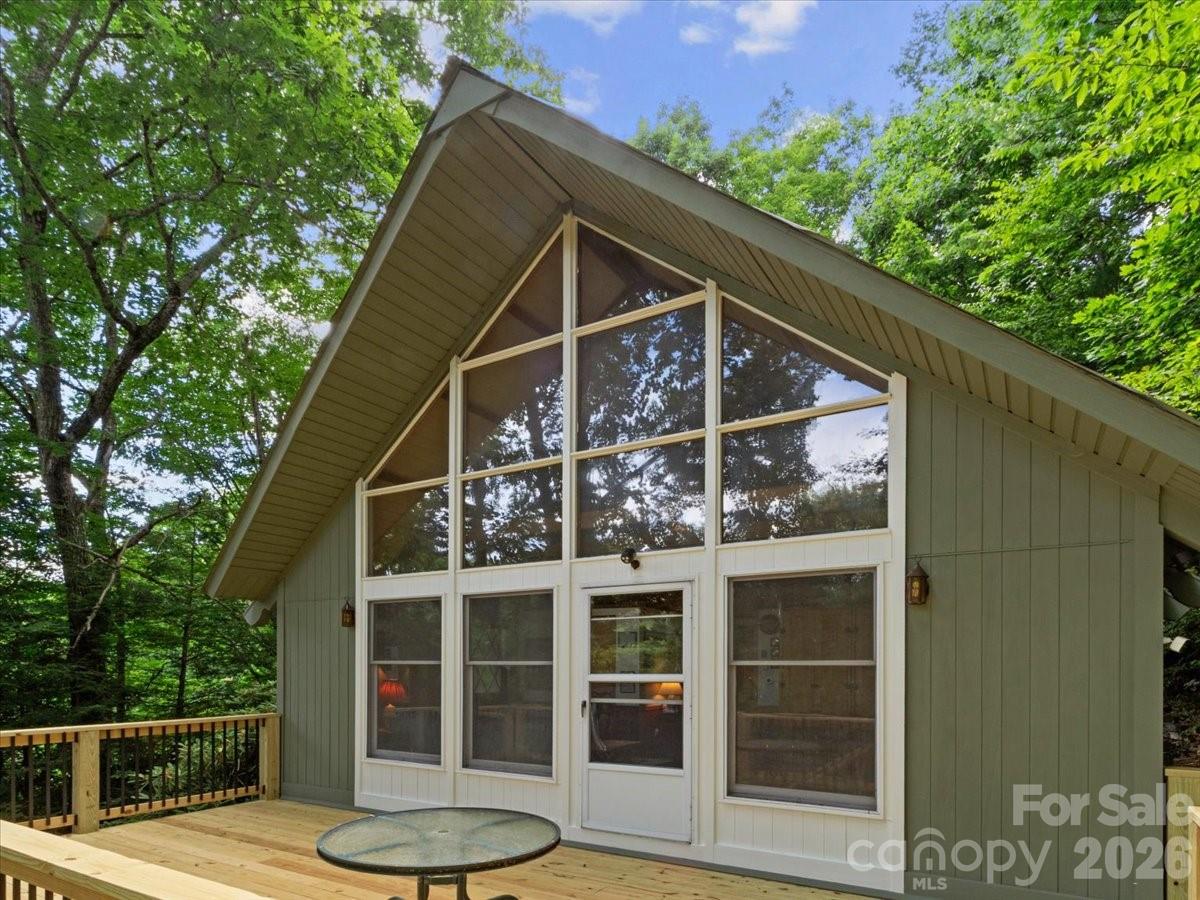 Enjoy mountain living at over 3,900 feet in elevation, where cool summer temperatures and cozy winters make every season something to look forward to. Located in the desirable Wolf Laurel community, this inviting home is just minutes from Hatley Pointe Resort and Wolf Laurel Country Club, offering the perfect blend of privacy, comfort, and year-round recreation.

The main level features a welcoming den with a propane stove and an open kitchen, creating a comfortable space for everyday living or gathering with family and friends after a day of hiking, golfing, or skiing. Built-in cabinetry throughout the home adds warmth, character, and plenty of storage. You'll also find a spacious laundry room with extra workspace and storage, along with a two-car garage that's perfect for vehicles, outdoor gear, or a workshop.

Upstairs, the second level offers a large loft with a propane gas log fireplace, making it an ideal spot to relax. This level also includes a spacious bedroom that's already plumbed for a wet bar, giving you the option to create a private guest suite or additional living space. A second bedroom or home office and a full bath provide even more flexibility. Step outside onto the brand-new deck to enjoy the fresh mountain air and beautiful long-range views.

The third-floor primary suite is a peaceful retreat with its own full bath and a Juliet balcony overlooking the mountains. Wake up each morning to incredible long-range views and the quiet beauty of the Blue Ridge Mountains.

Additional features include a durable metal roof and a whole-house Generac generator for added peace of mind.

As part of the gated Wolf Laurel community, you'll have access to amenities including an outdoor pool, tennis courts, and a fitness center. With Hatley Pointe Resort just minutes away, you'll enjoy easy access to skiing, snowboarding, hiking, mountain biking, and countless other outdoor adventures.

Whether you're looking for a full-time home, a seasonal mountain getaway, or an investment property, this home offers an exceptional opportunity to enjoy everything mountain living has to offer.