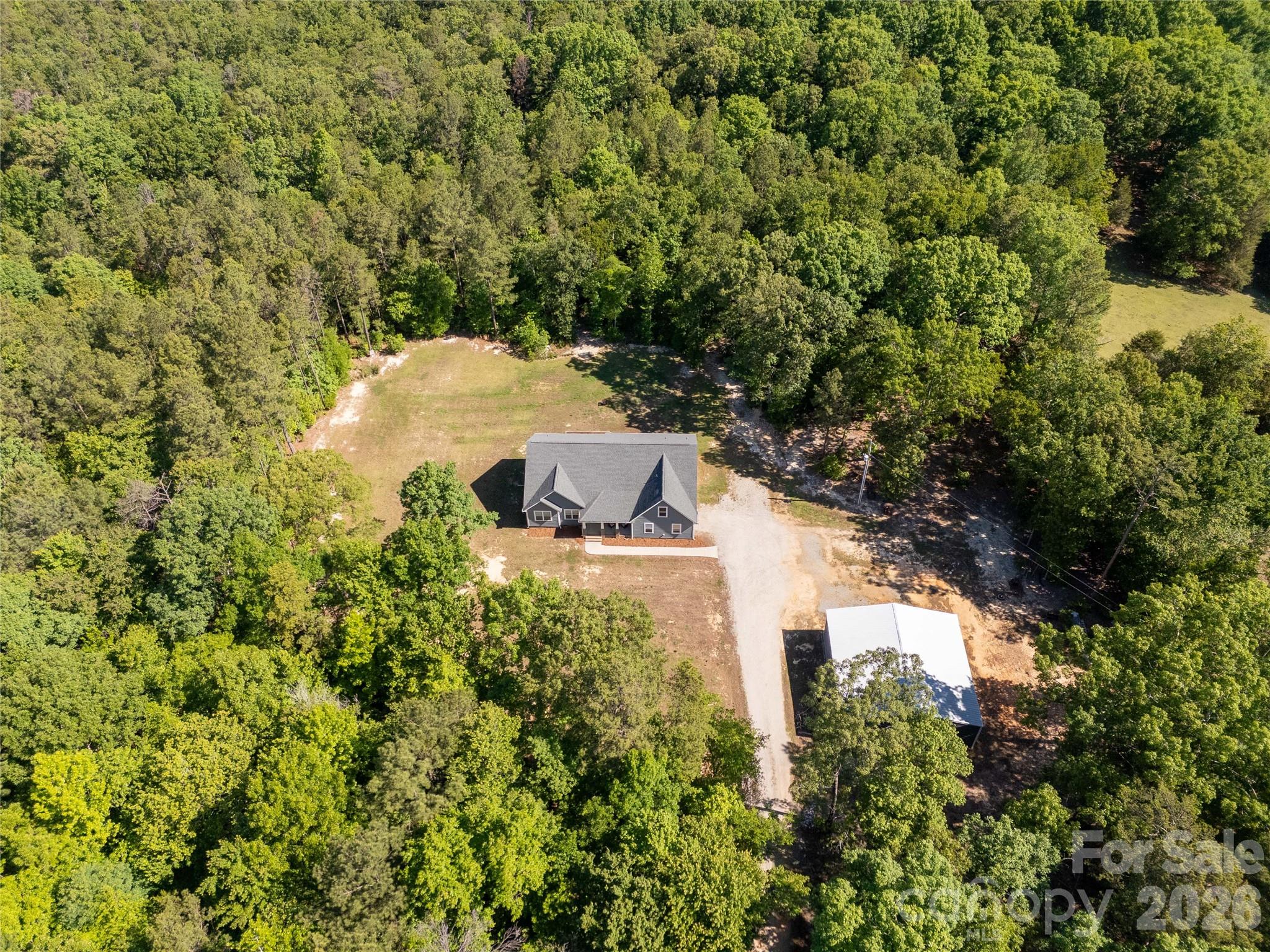 Tucked away on 14.289 acres of peaceful privacy, this home offers the kind of lifestyle buyers dream about but rarely find. Surrounded by room to roam, this property is perfect for those craving country living, outdoor adventure, or simply space away from neighbors. Whether you enjoy hunting, riding ATVs, keeping animals, gardening, or simply enjoying the quiet from your porch, this property delivers the freedom to live life your way.

Built with durable Hardie board siding and thoughtfully designed for both comfort and functionality, this spacious home features 4 bedrooms and 3 full baths on the main level, including TWO primary suites downstairs, making it an incredible setup for multi-generational living, guests, or added flexibility. Upstairs offers a large bonus room with an additional full bath that could easily serve as a media room, home office, guest retreat, or playroom.

Inside, the open-concept layout and split-bedroom floor plan create the perfect balance of togetherness and privacy. The main living areas flow effortlessly, making everyday living and entertaining feel easy and inviting. The windows bring in natural light and showcase the peaceful setting surrounding the home.

Outside is where this property truly shines. The 40x40 shop provides endless possibilities for equipment storage, hobbies, a workshop, recreational vehicles, or outdoor gear. A double garage, covered front porch, and back deck add even more space to enjoy the outdoors and take in the quiet surroundings. With over 14 acres, there is room for hunting, ATV trails, animals, homesteading, gardening, or simply enjoying the privacy that is becoming harder and harder to find.

Located in the highly desirable Buford School District and conveniently positioned near Monroe, Lancaster, Pageland, Waxhaw, and Charlotte, NC, this property offers the perfect blend of country living and accessibility.

If you've been searching for a private acreage home, home with land, newer construction (this home was built in 2021), multi-generational floor plan, property with a shop, hunting property, or mini farm potential in the Buford area, this one brings the whole country-living starter pack.